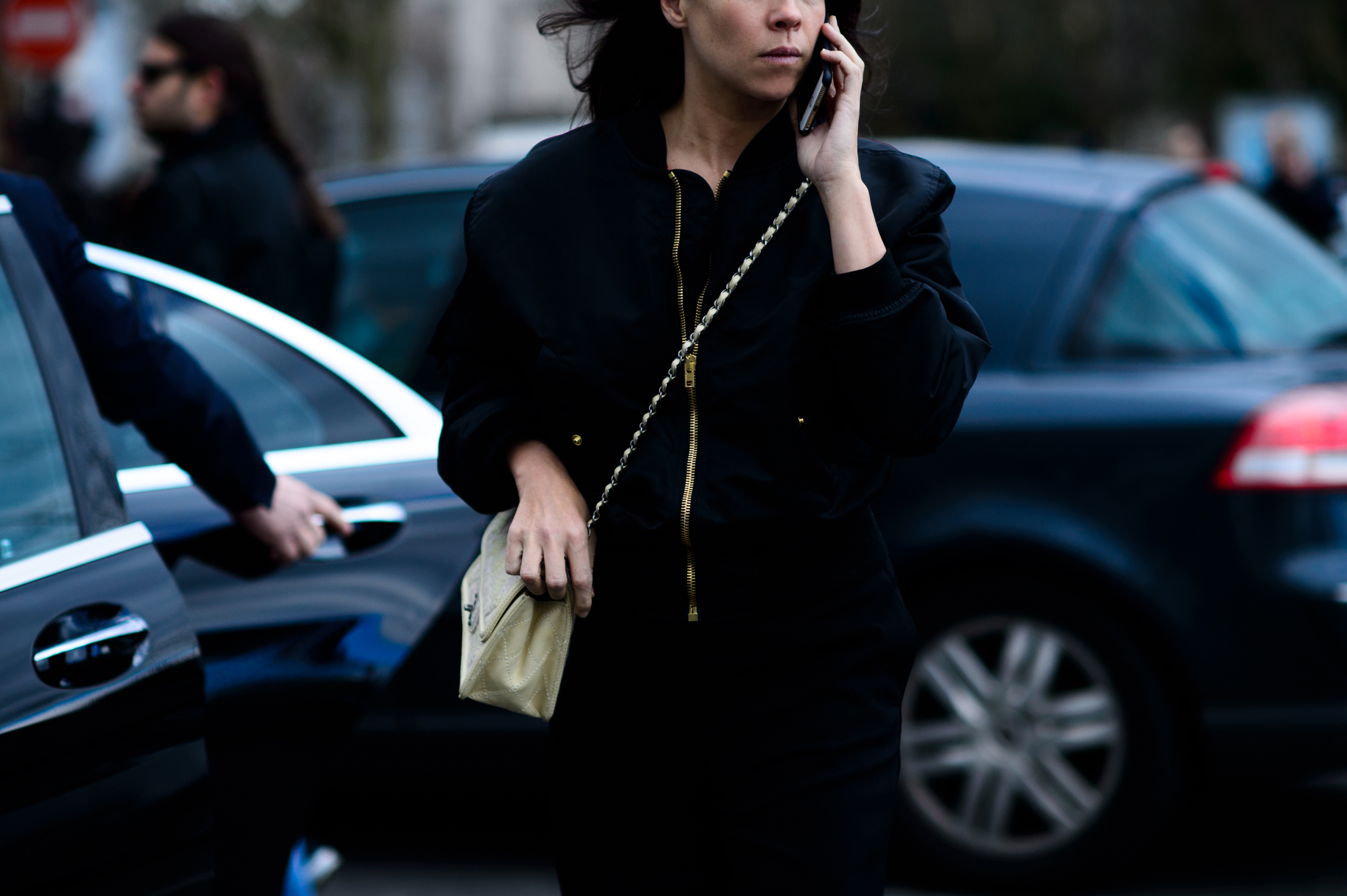 Woman wearing black jacket with cream handbag