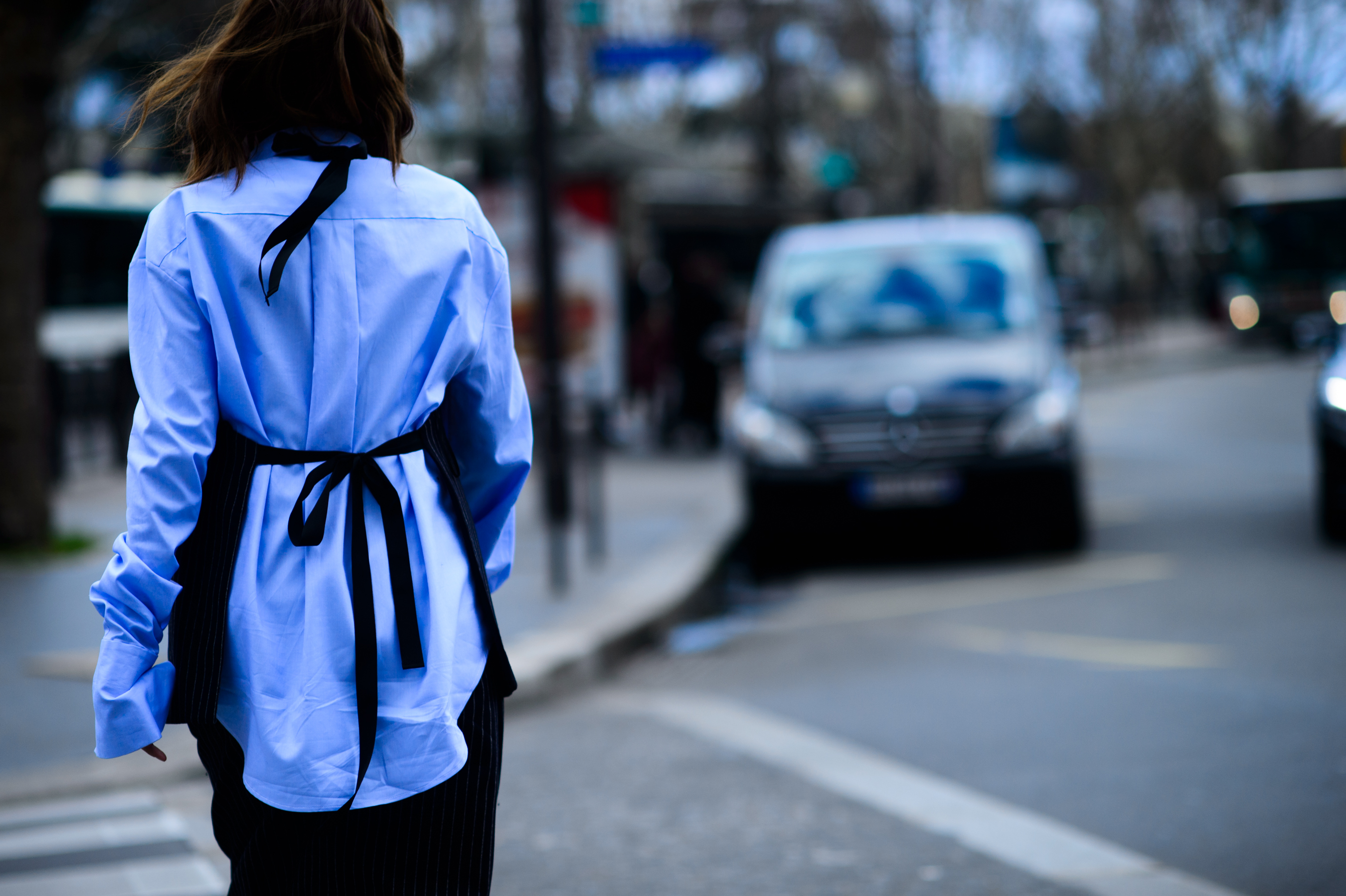 Back of woman wearing blue shirt with black detail bow