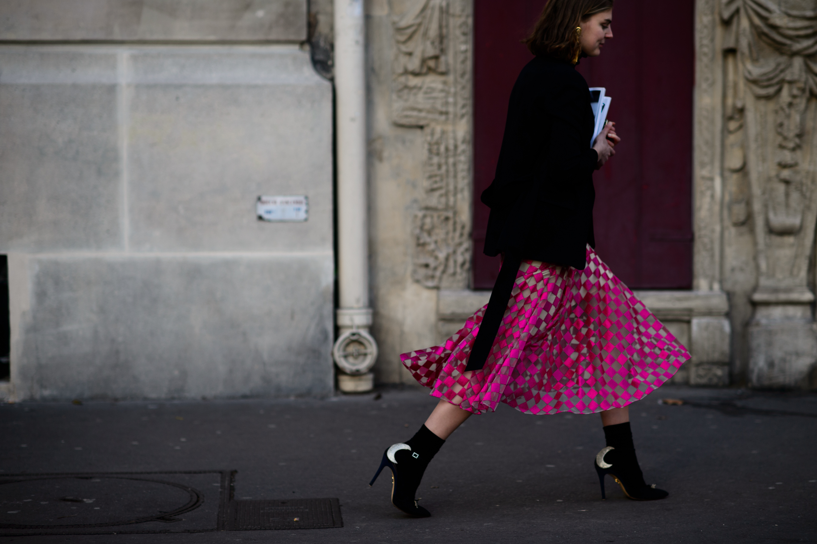 Woman walking in pink diamond pattern skirt