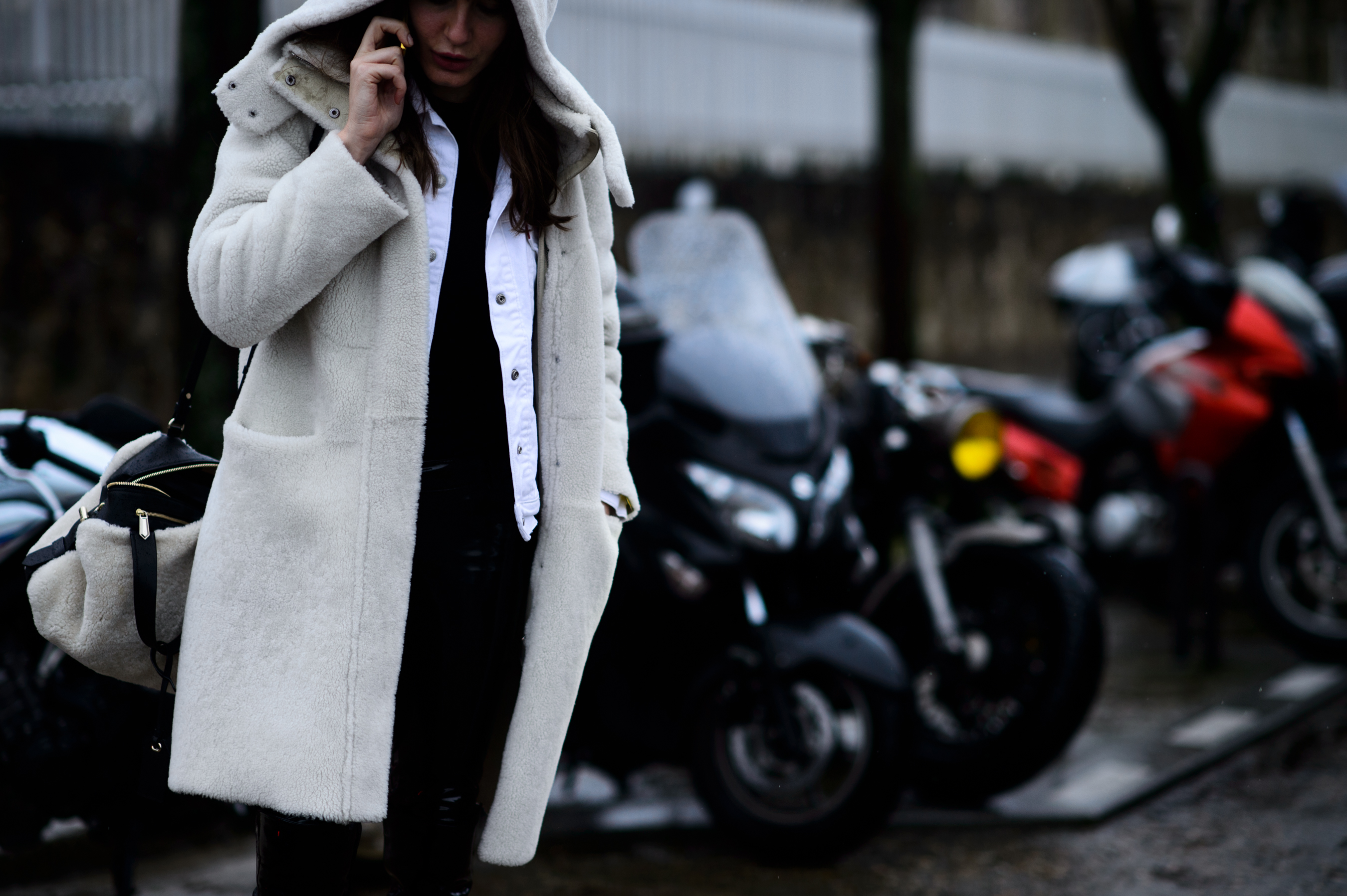 Woman wearing white shearling hooded coat