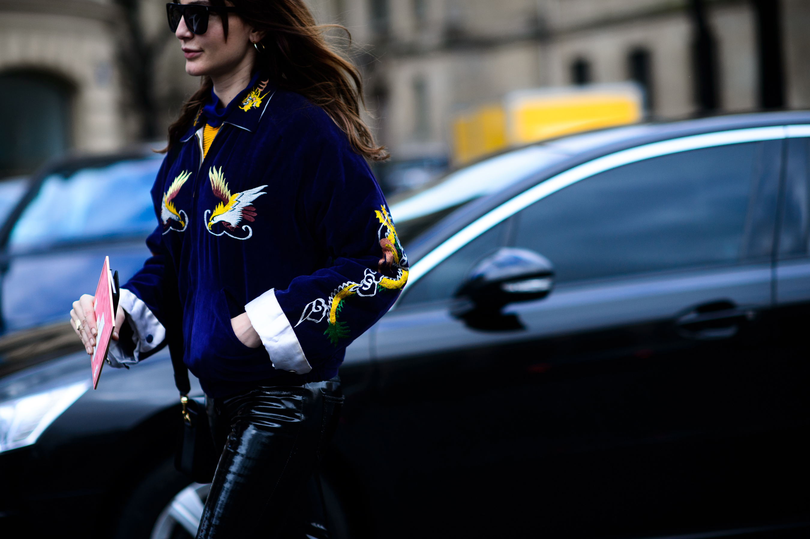 Woman in blue graphic jacket with hand in pocket