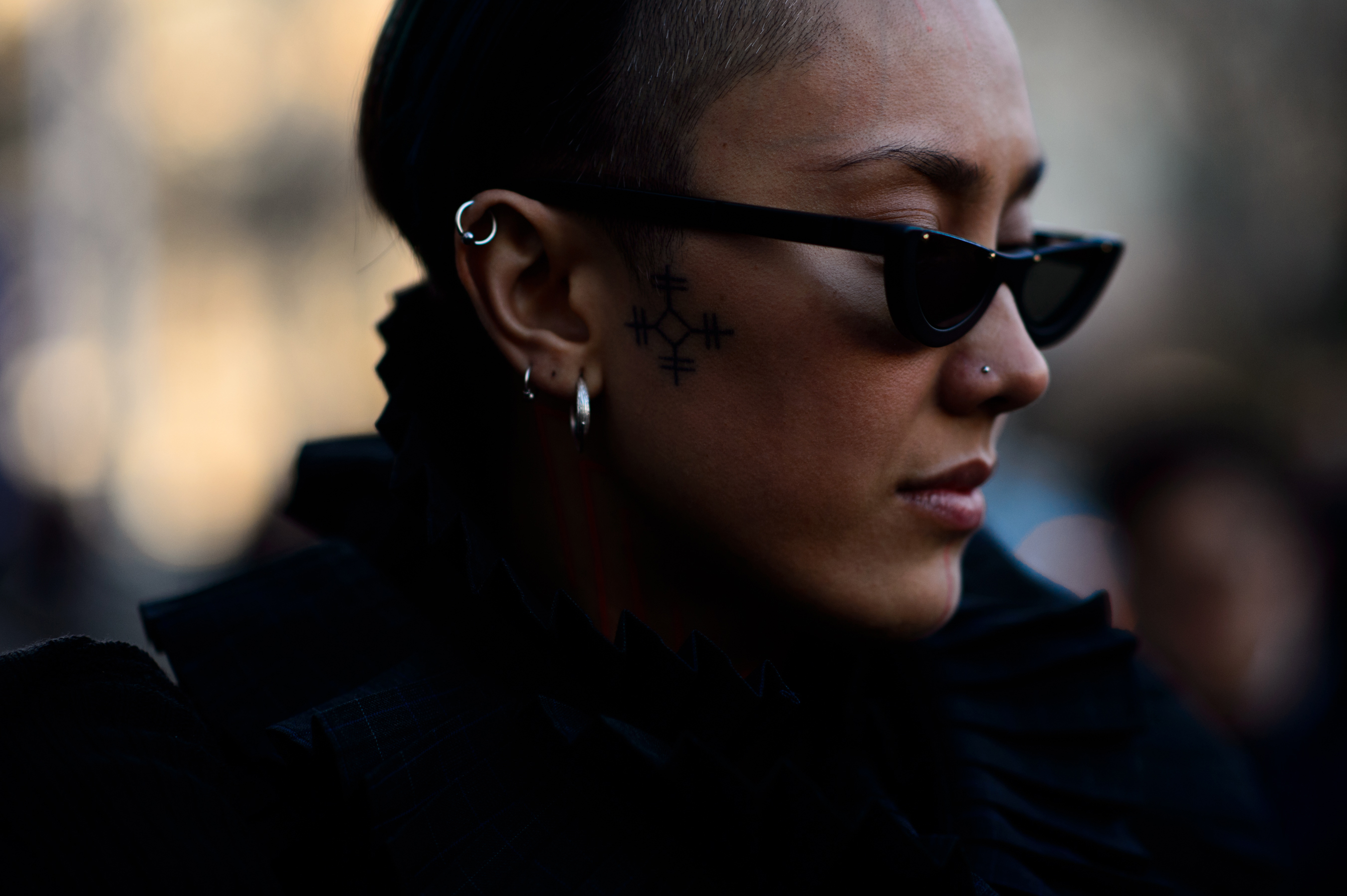 Woman with dark sunglasses and silver earrings