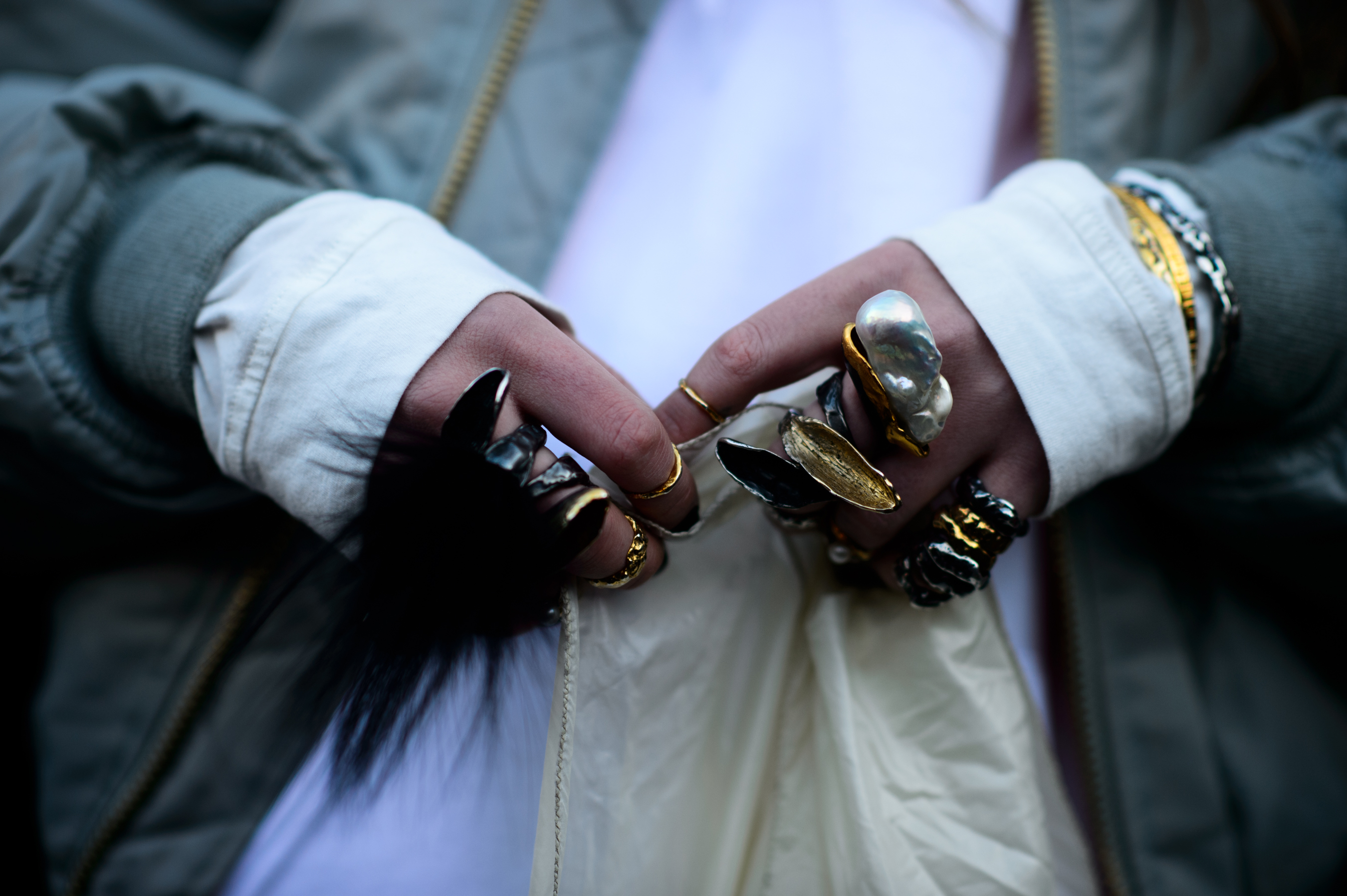 Hands clutched together with gold and black rings