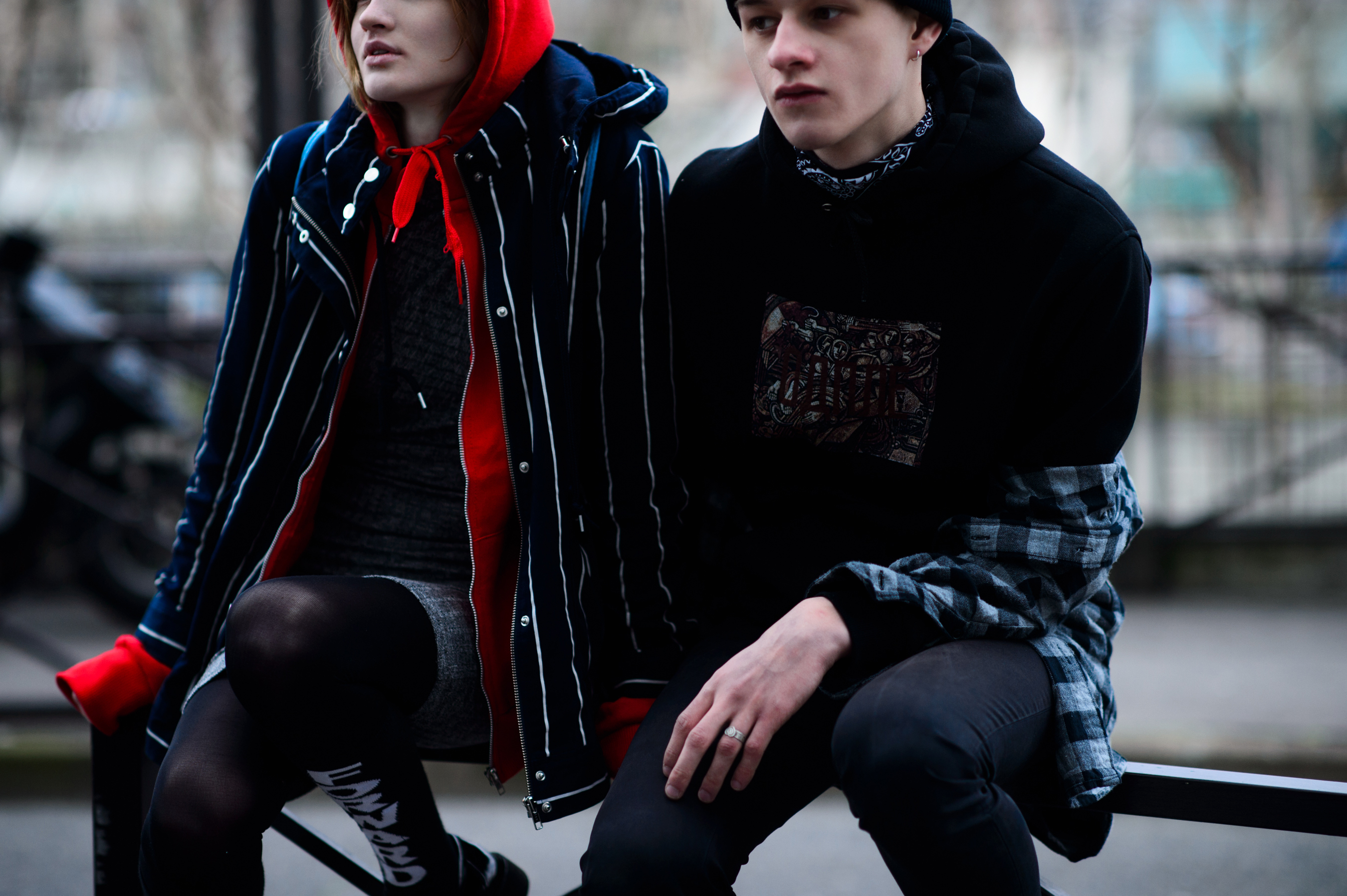 Couple sitting on fence wearing black