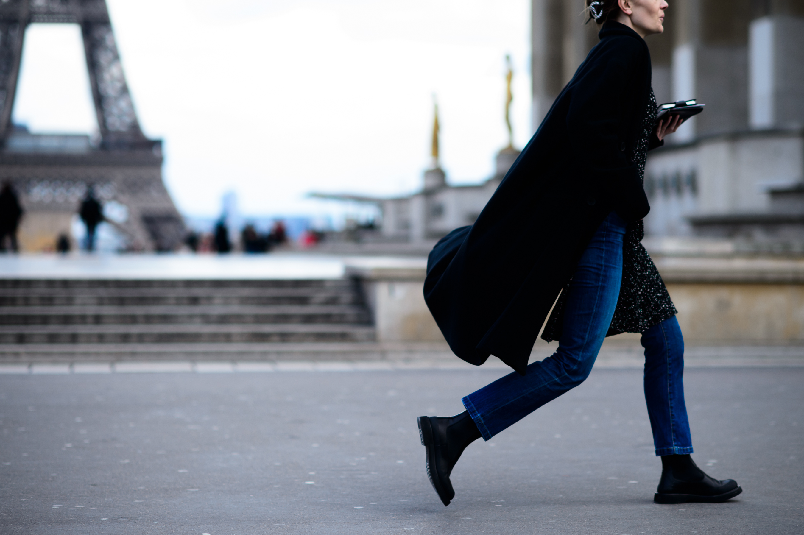Woman walking in flowing black coat