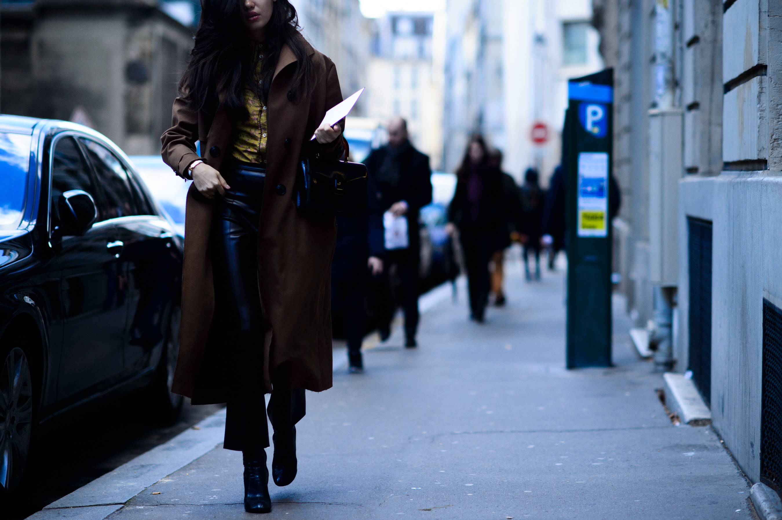 Woman walking in brown coat and leather trousers