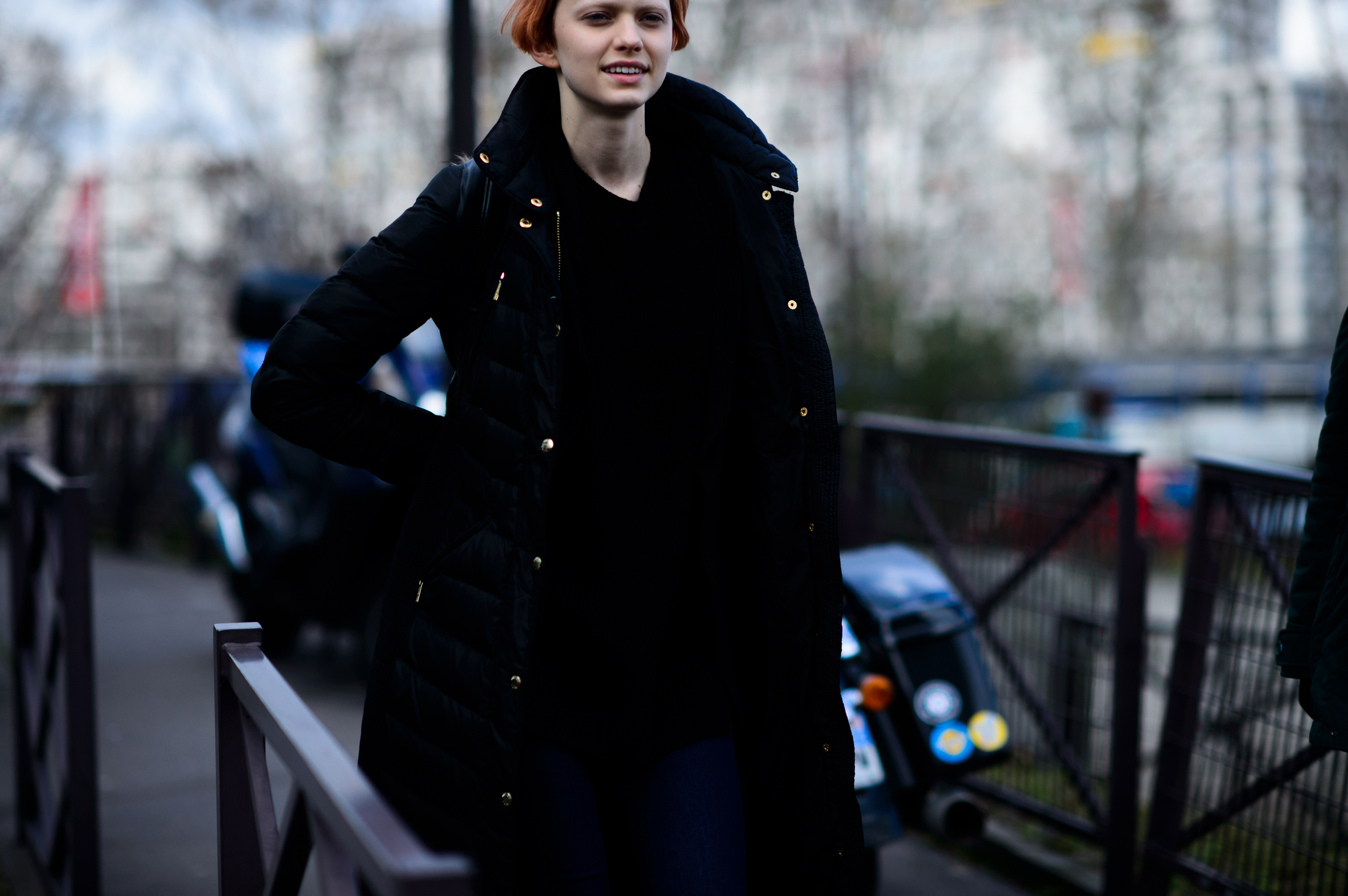 Model with red hair wearing black coat
