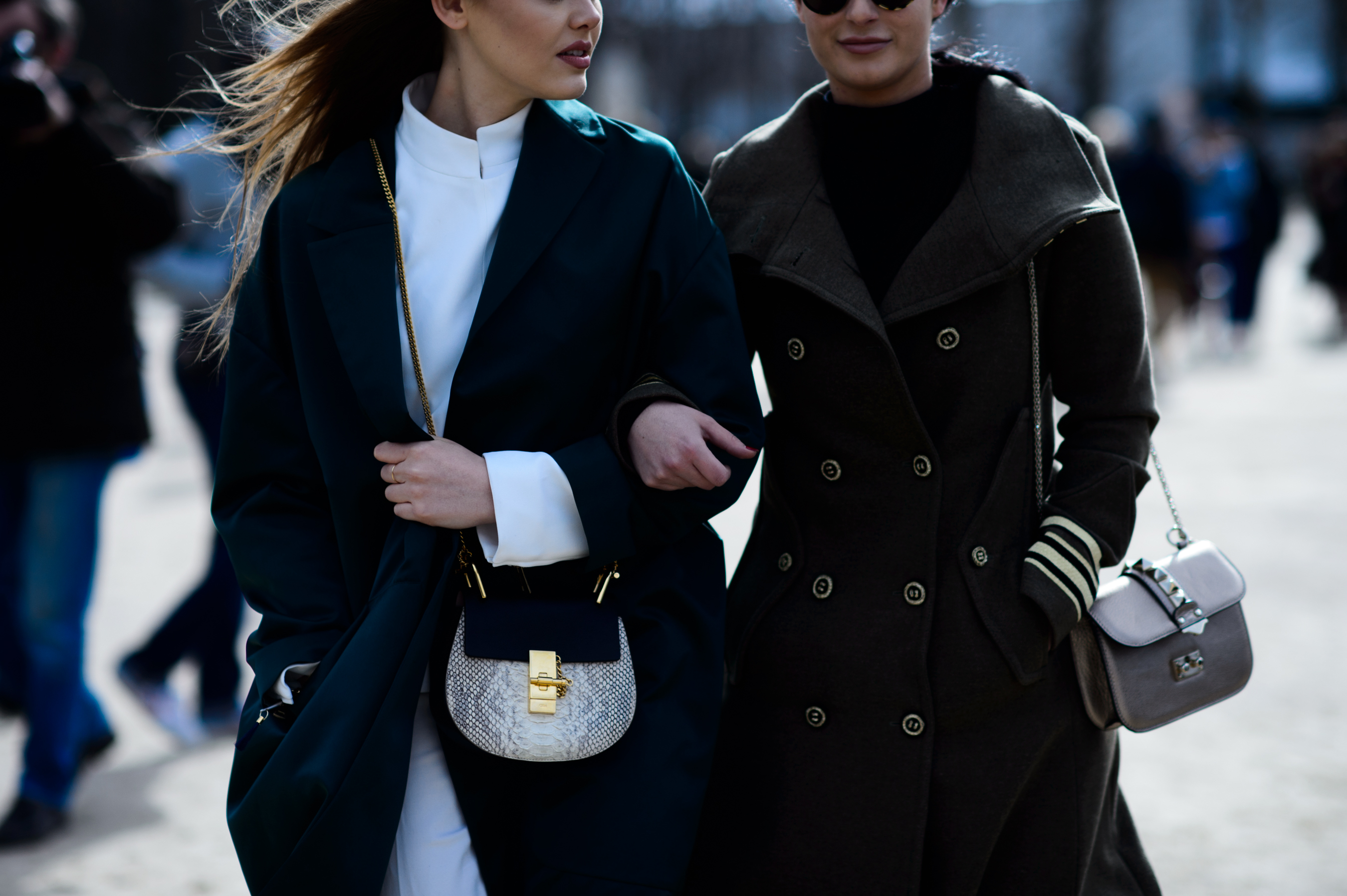 Two women wearing long coats