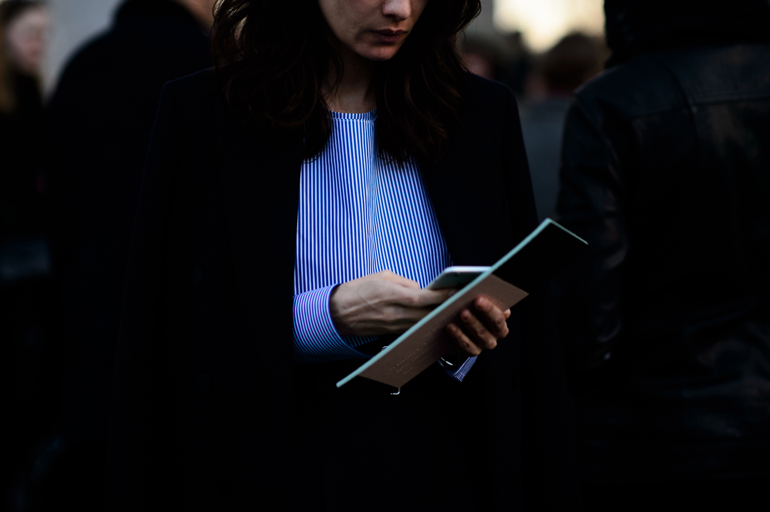 Woman with invitations in blue stripe top