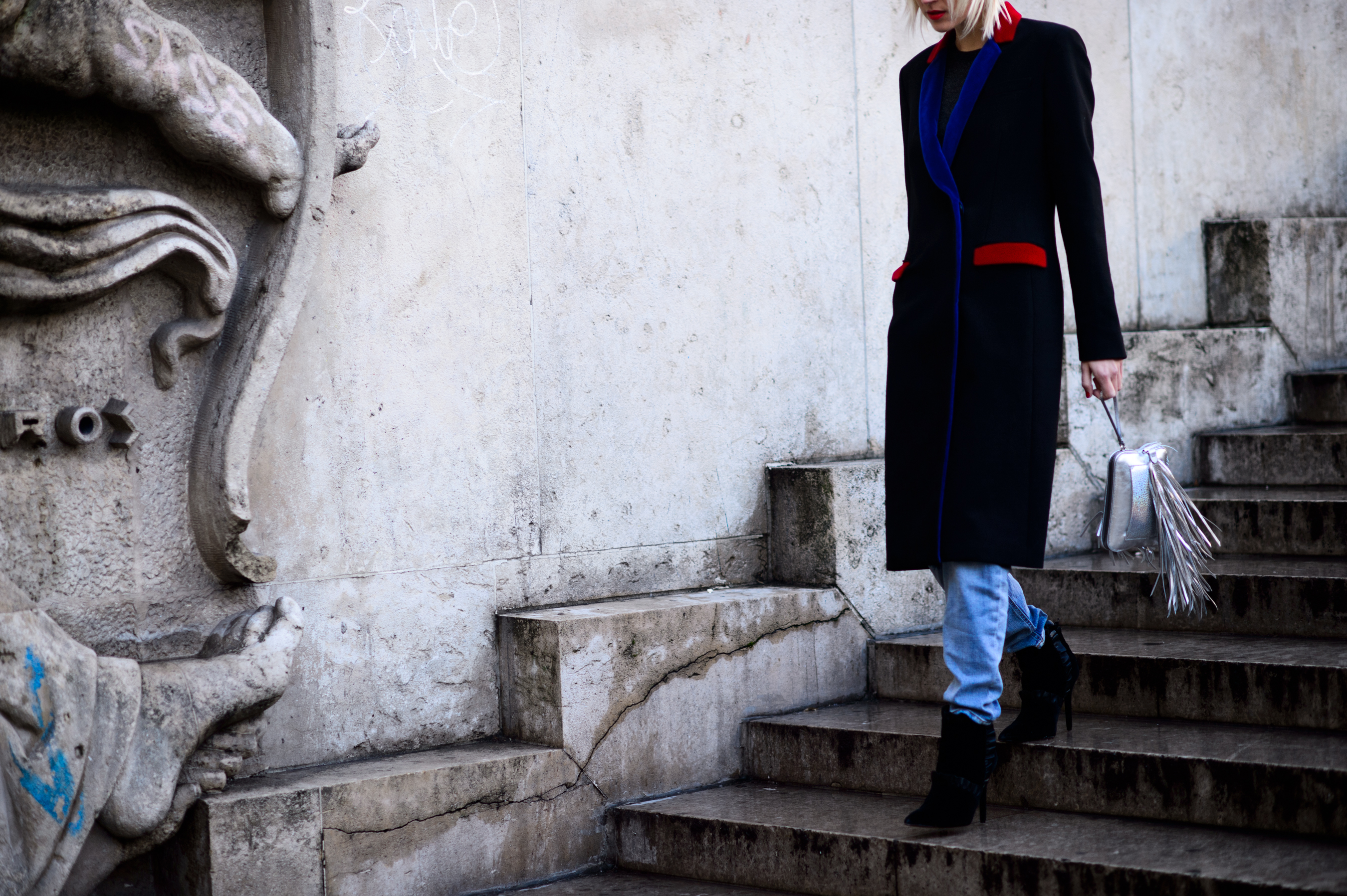 Woman wearing blue detail coat walking down stairs