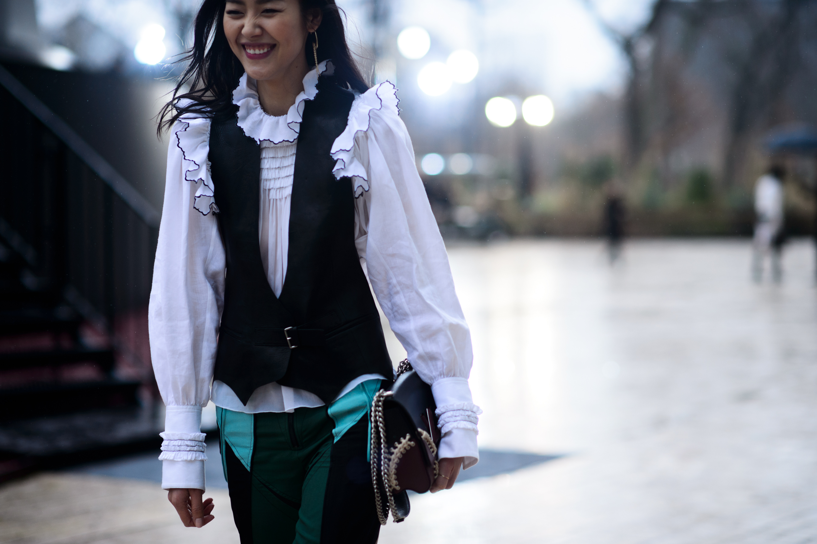 Model laughing wearing white shirt under black waistcoat