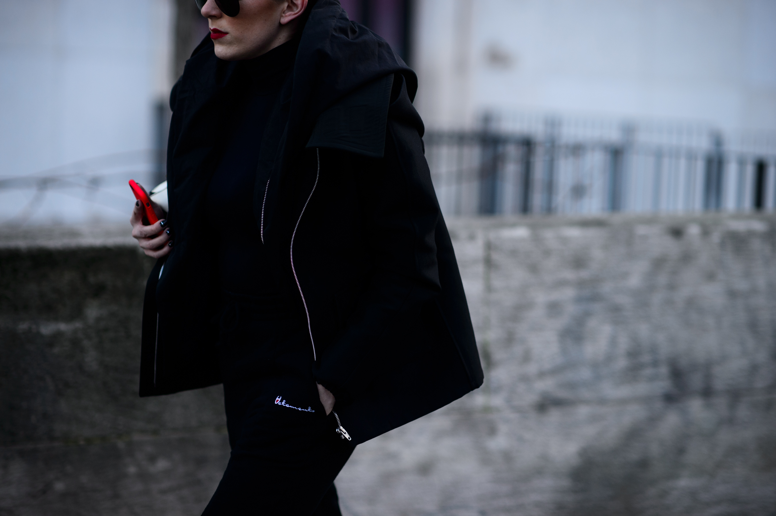 Woman in black jacket with red phone case