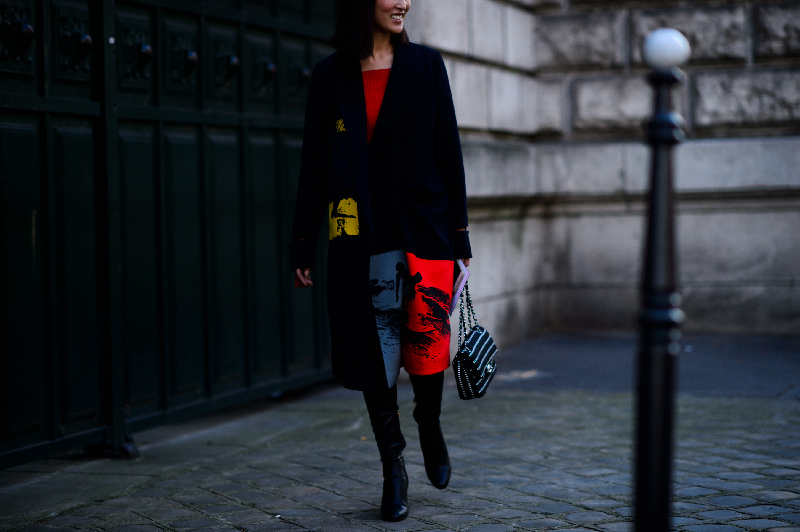 Woman walking in black, grey and red knit dress
