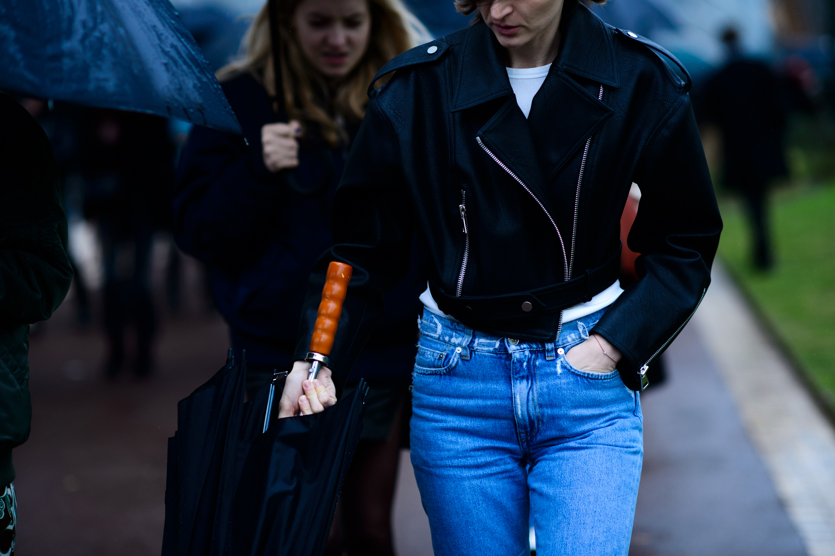 Woman wearing blue jeans holding umbrella