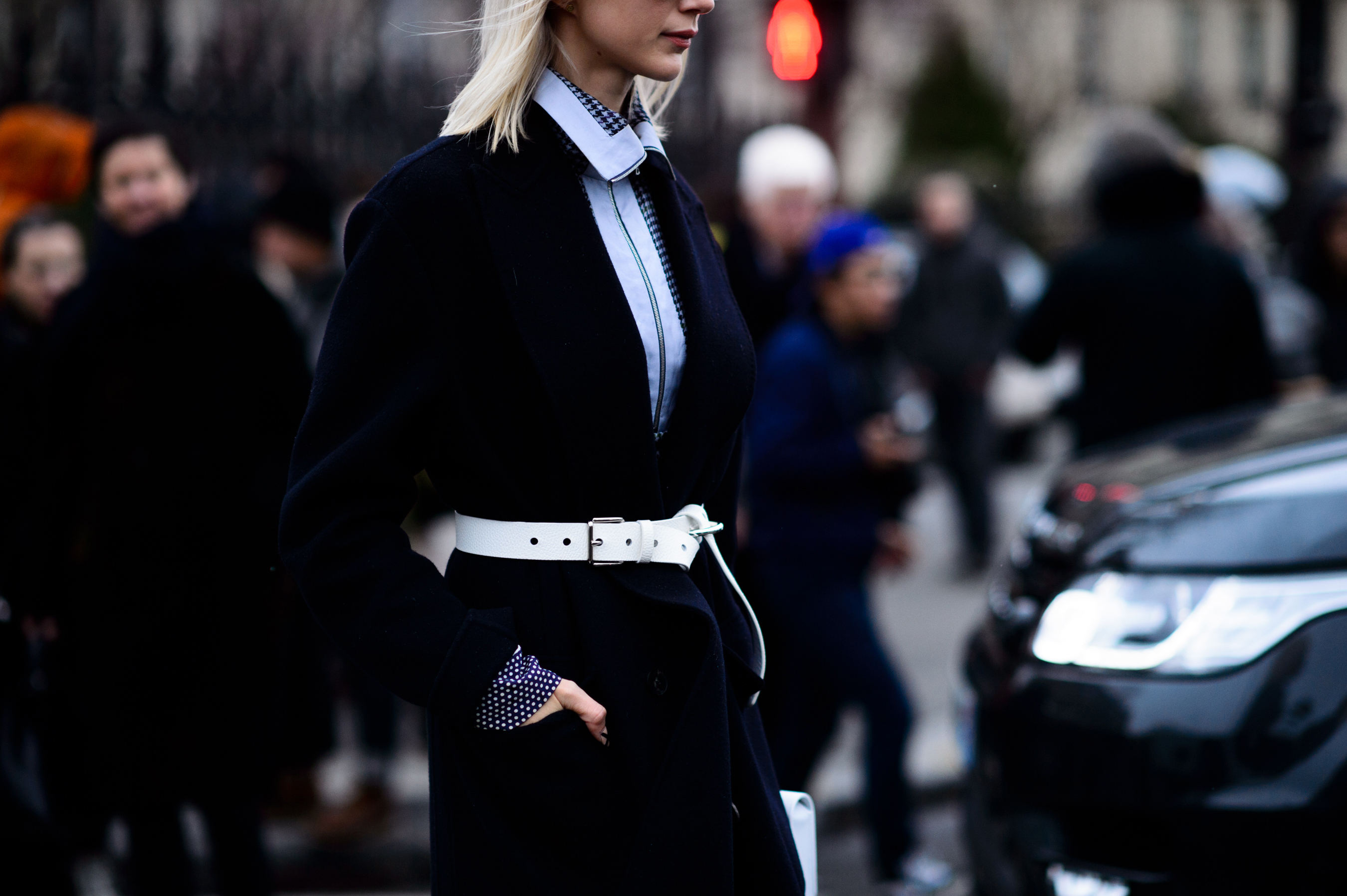 Woman wearing white belt and blue coat