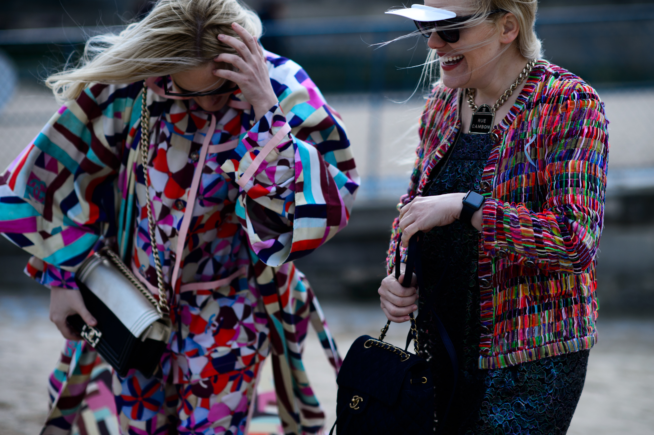 Two women wearing multicoloured outfits in the wind