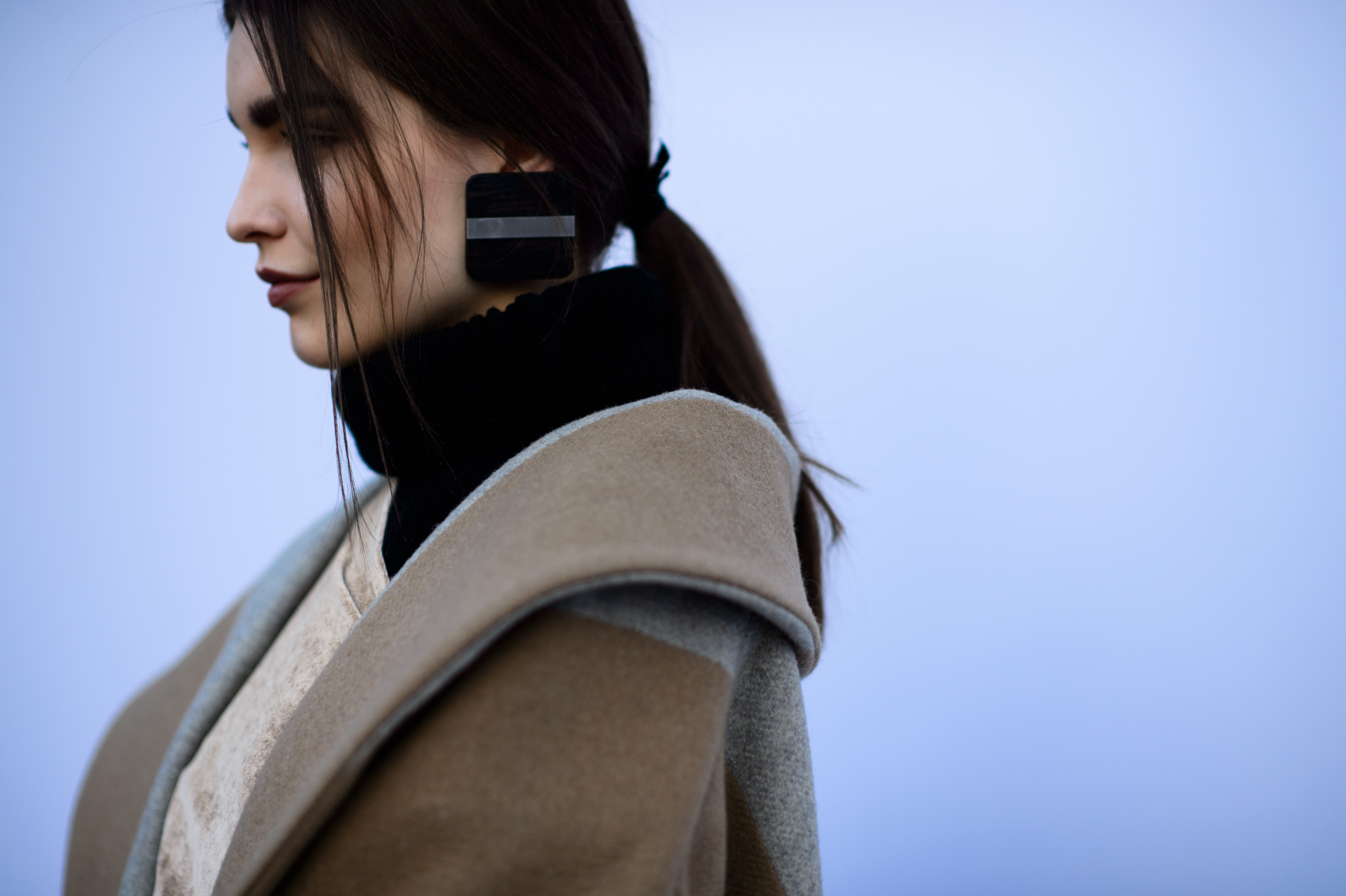 Girl wearing beige coat and earring