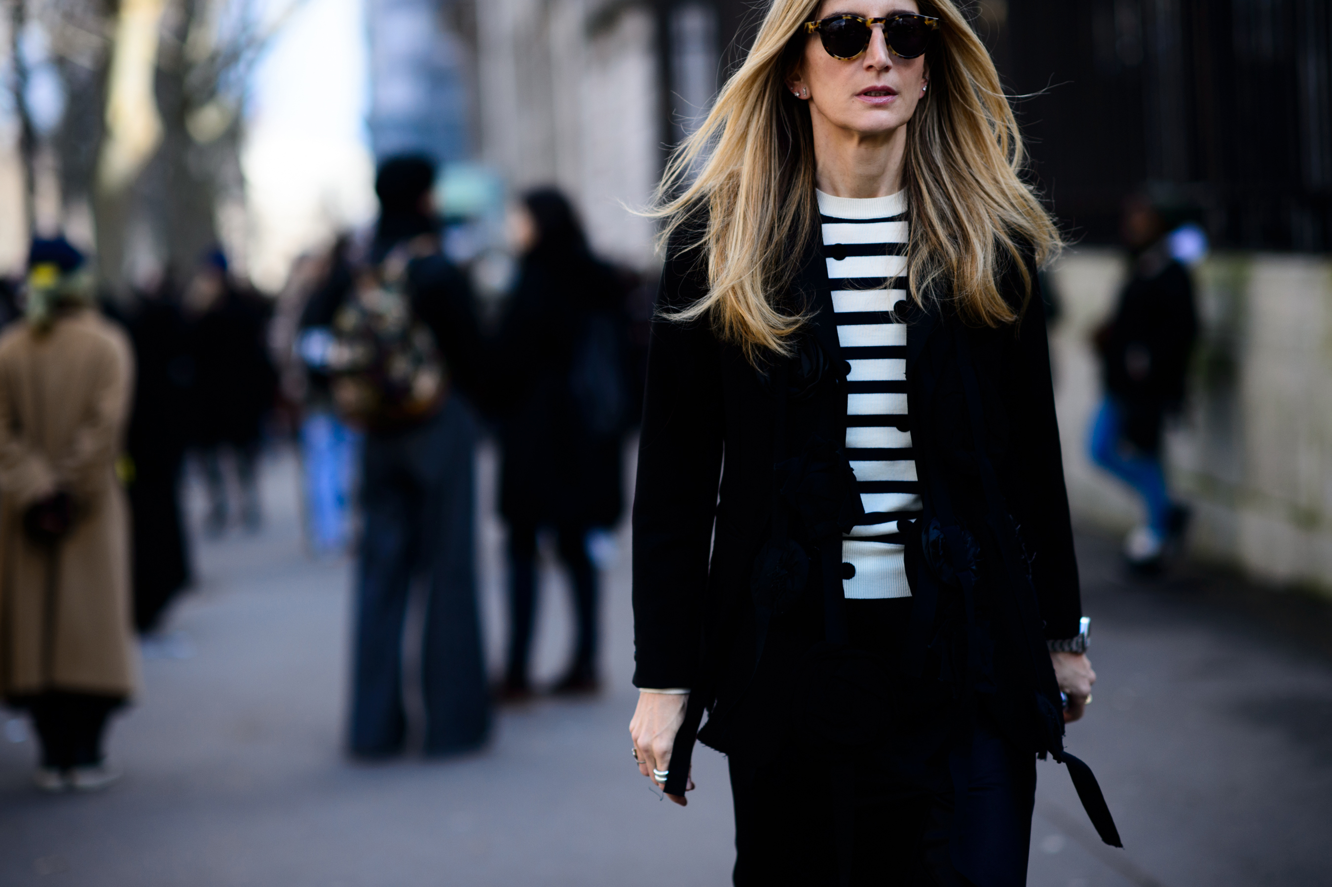 Woman with blonde hair in striped top under blazer