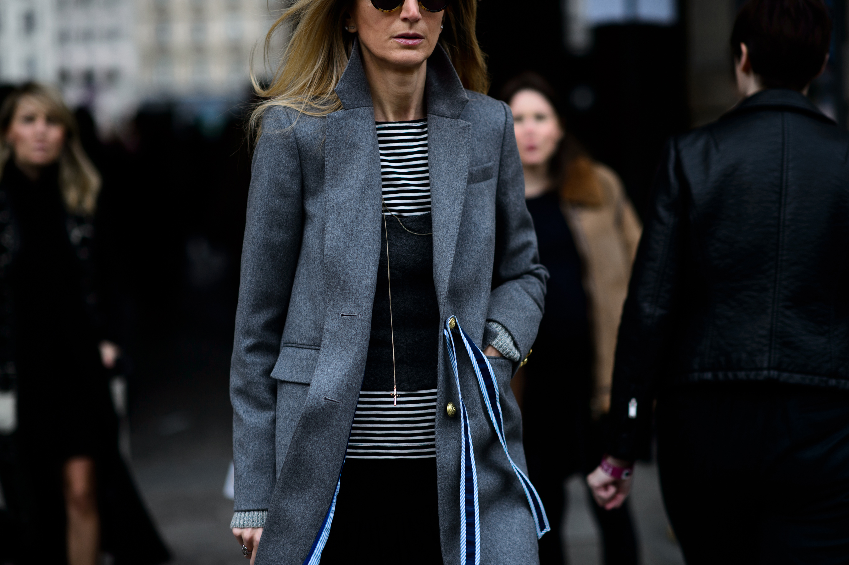 Women in grey coat with hand in pocket