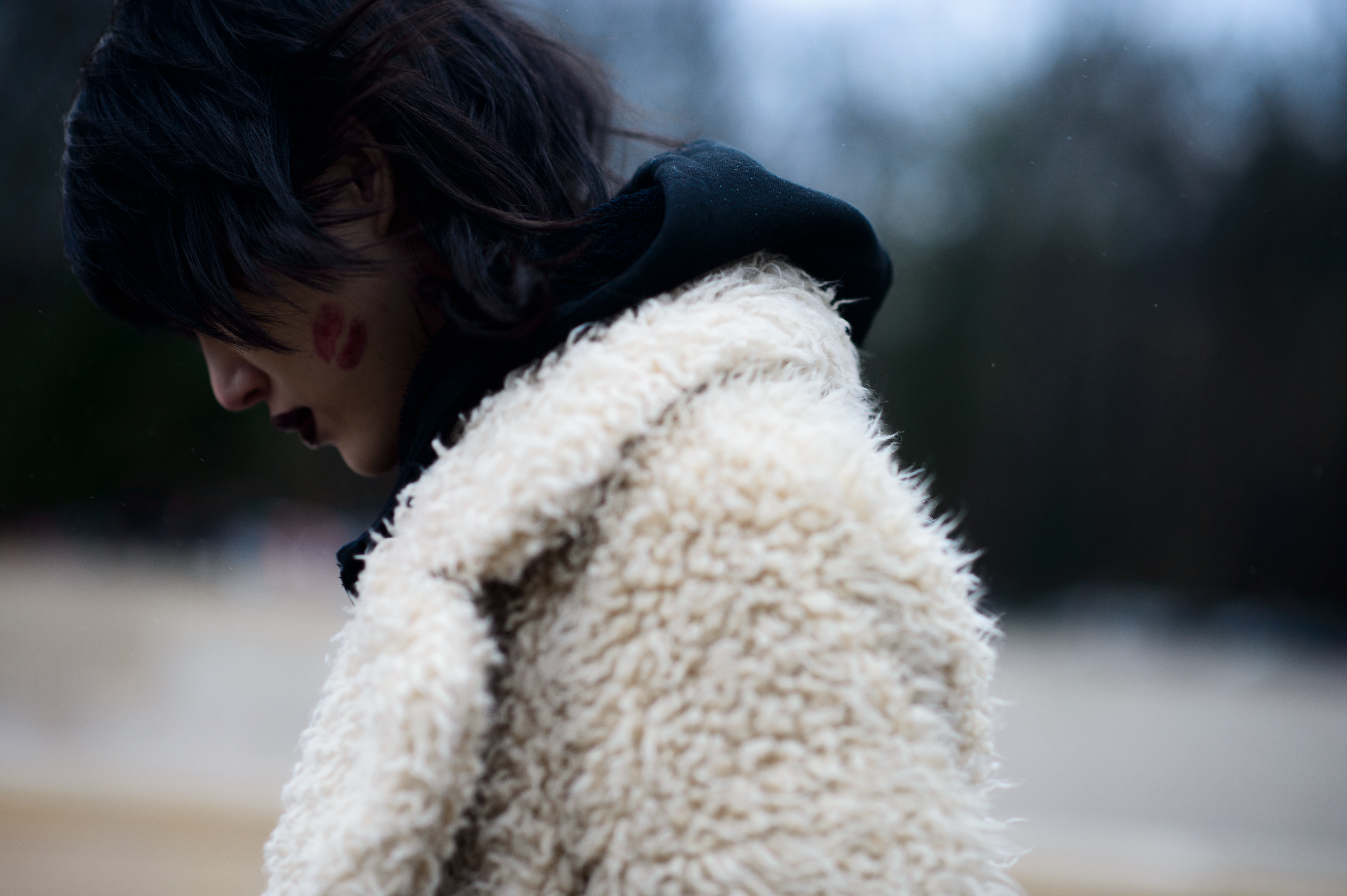 Closeup of model wearing white shearling and black hoodie