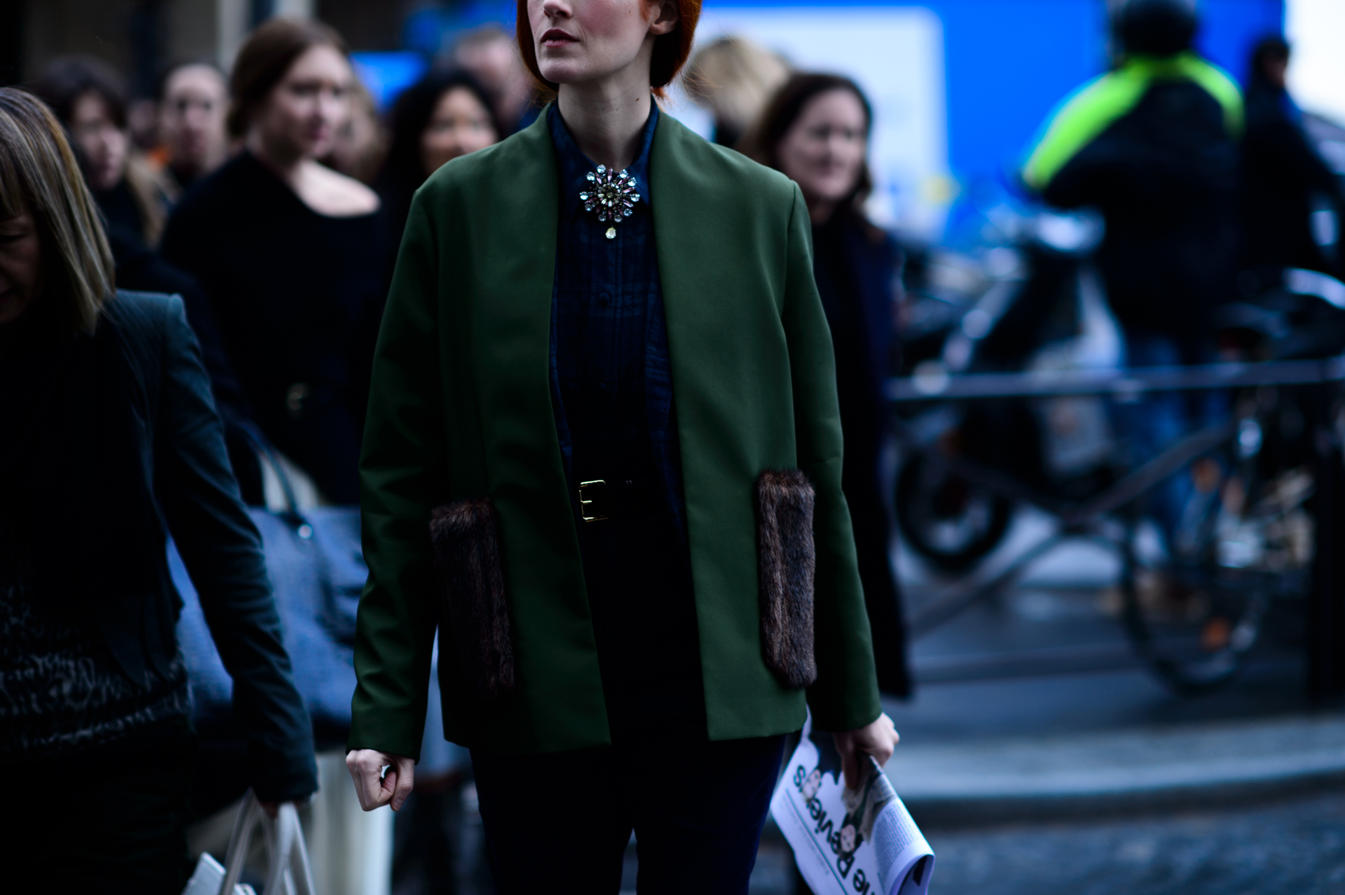 Red haired woman in green jacket with fur pockets
