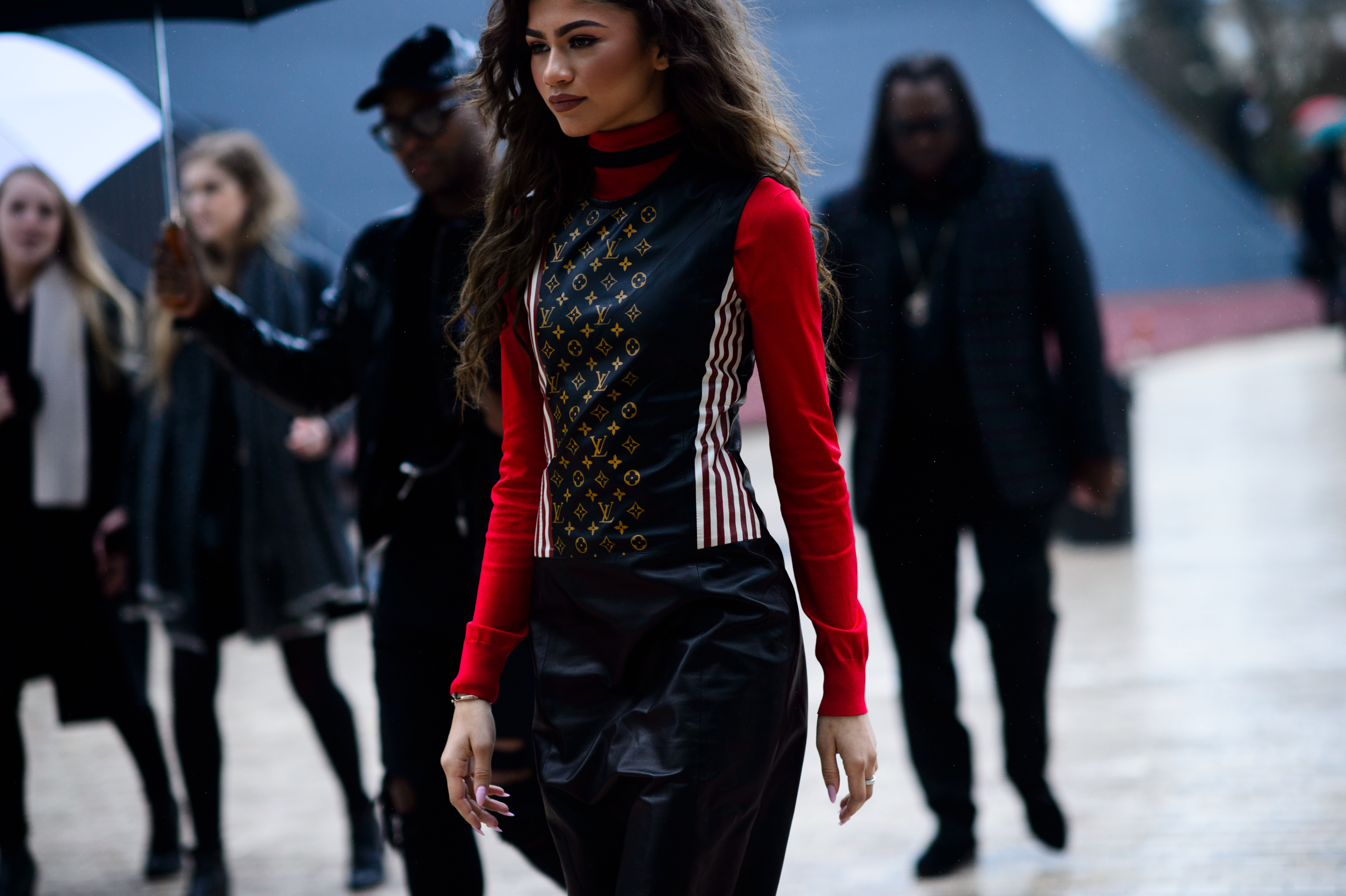 Woman wearing red shirt under logo black vest
