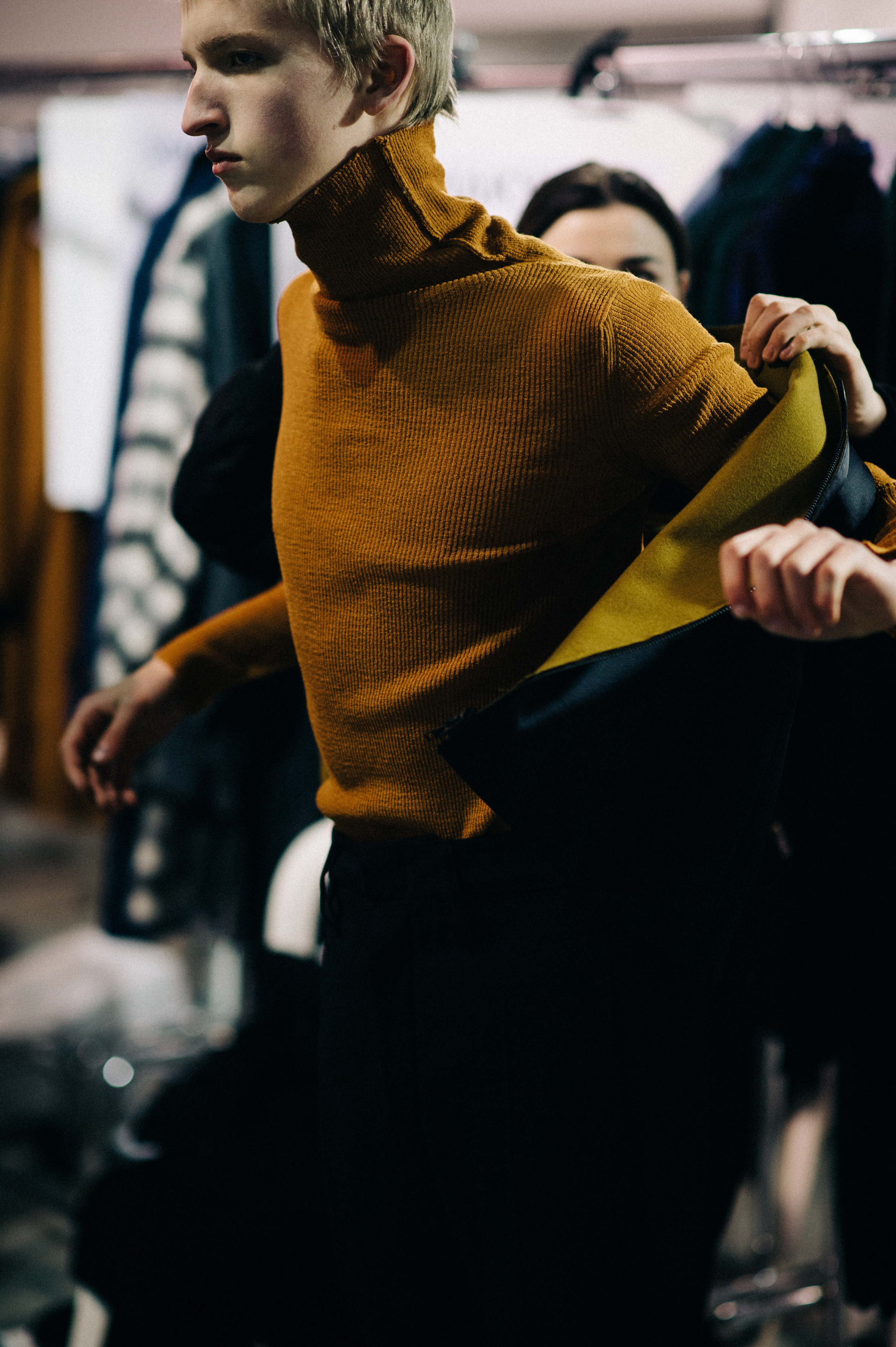 Blonde male model getting dressed