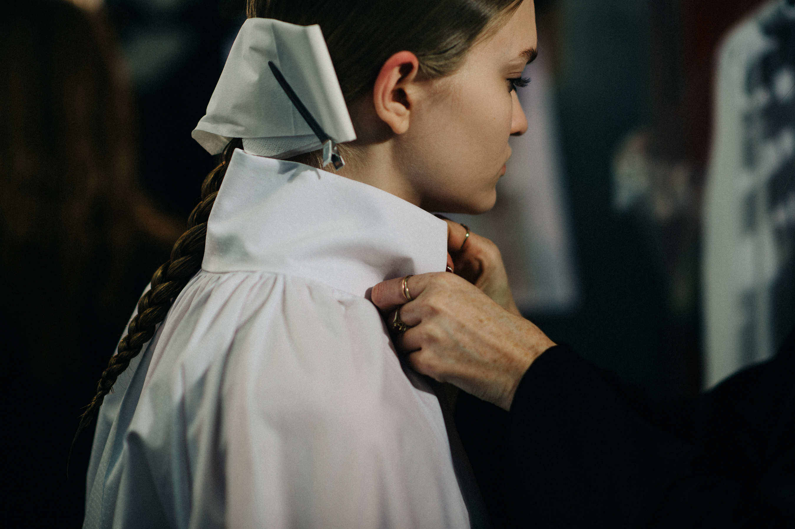Model getting dressed in white shirt