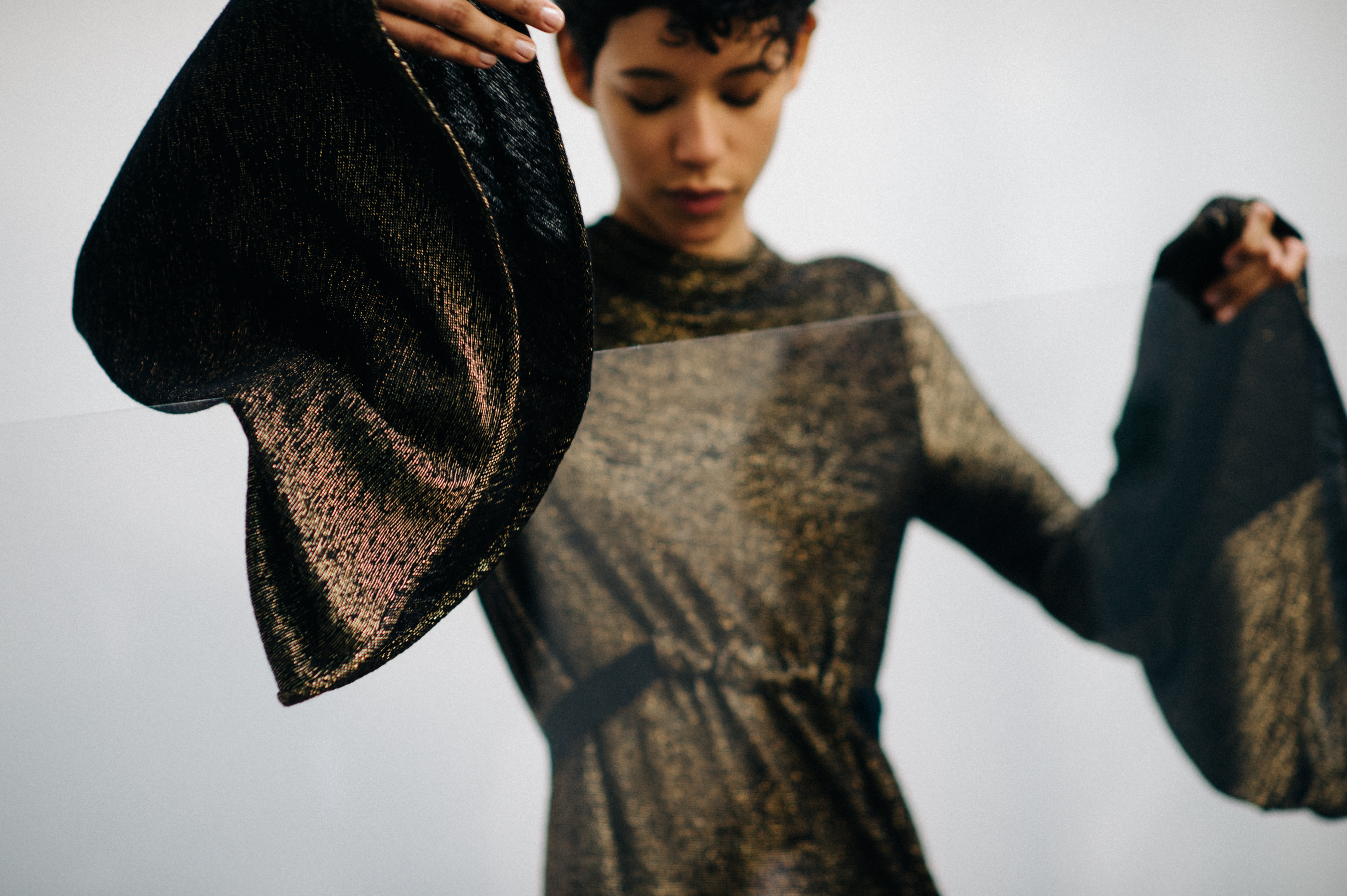 Model wearing golden bell sleeve dress