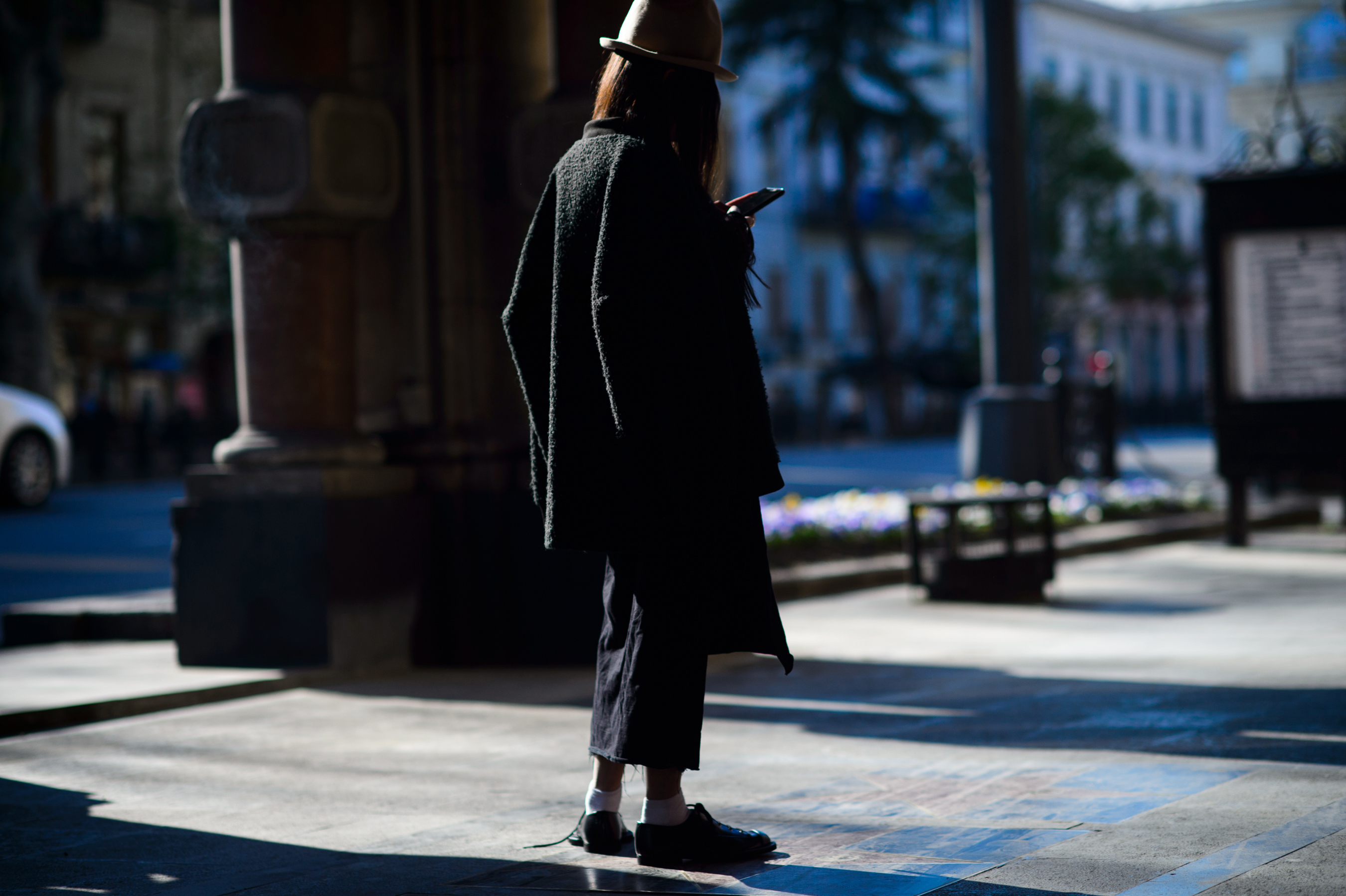 Blogger wearing dark outfit and hat