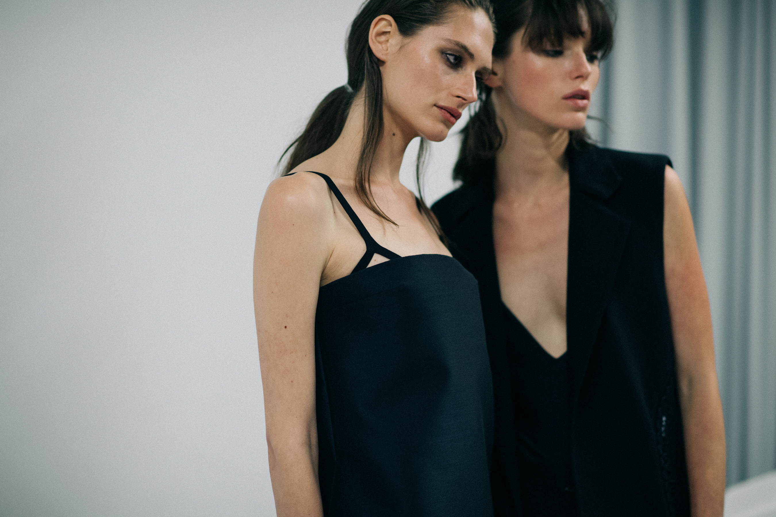 Two models dressed in black dresses