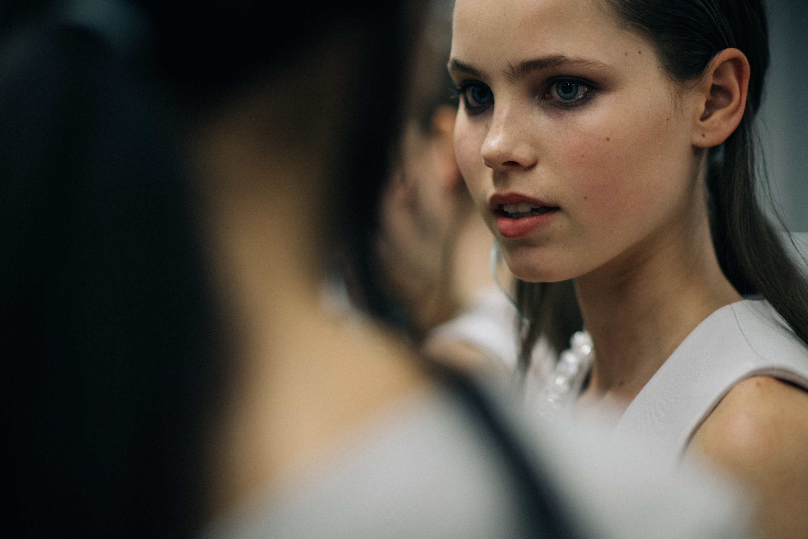 Model wearing white dress before show