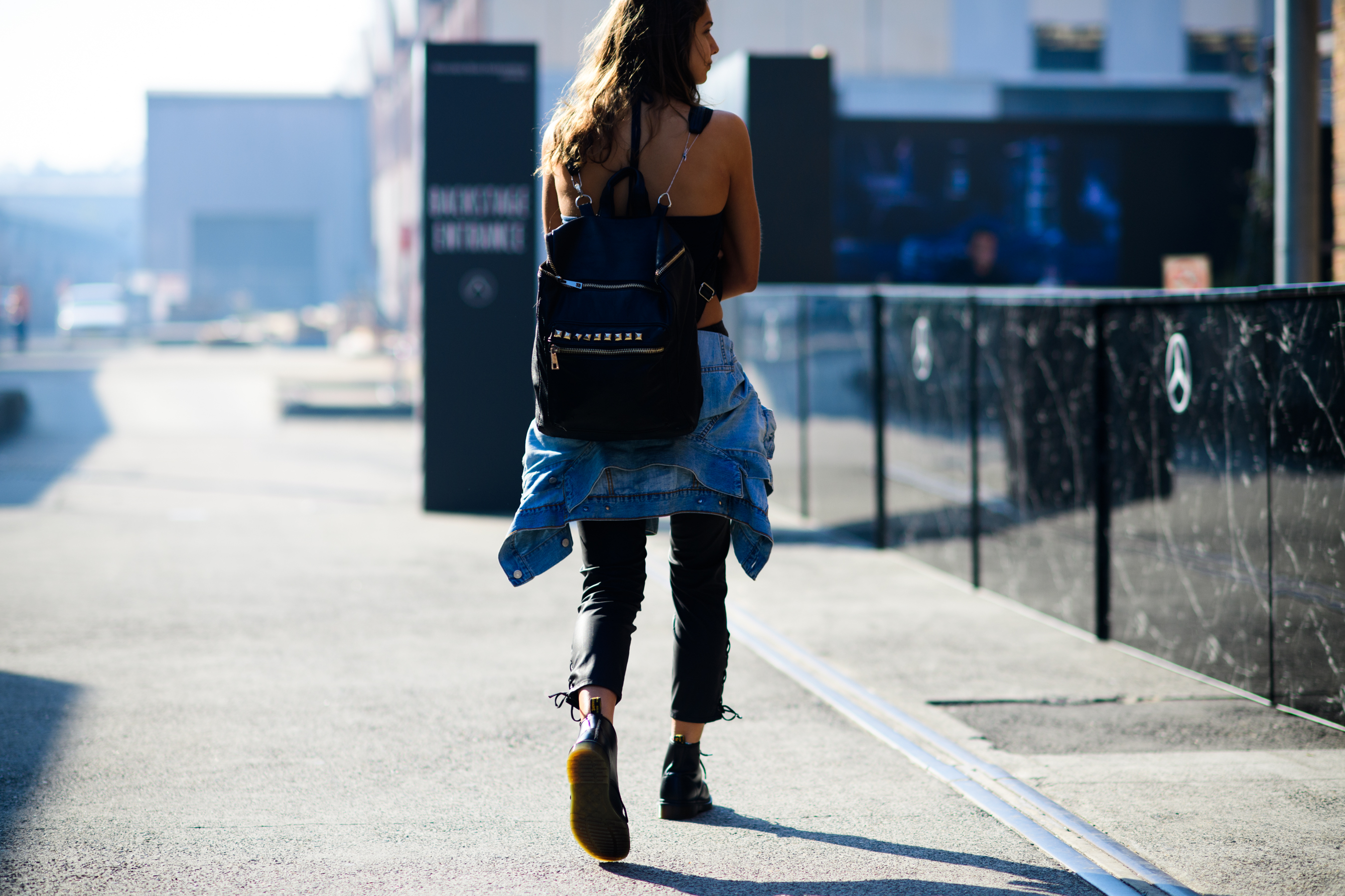 Model wearing leather pants and backpack