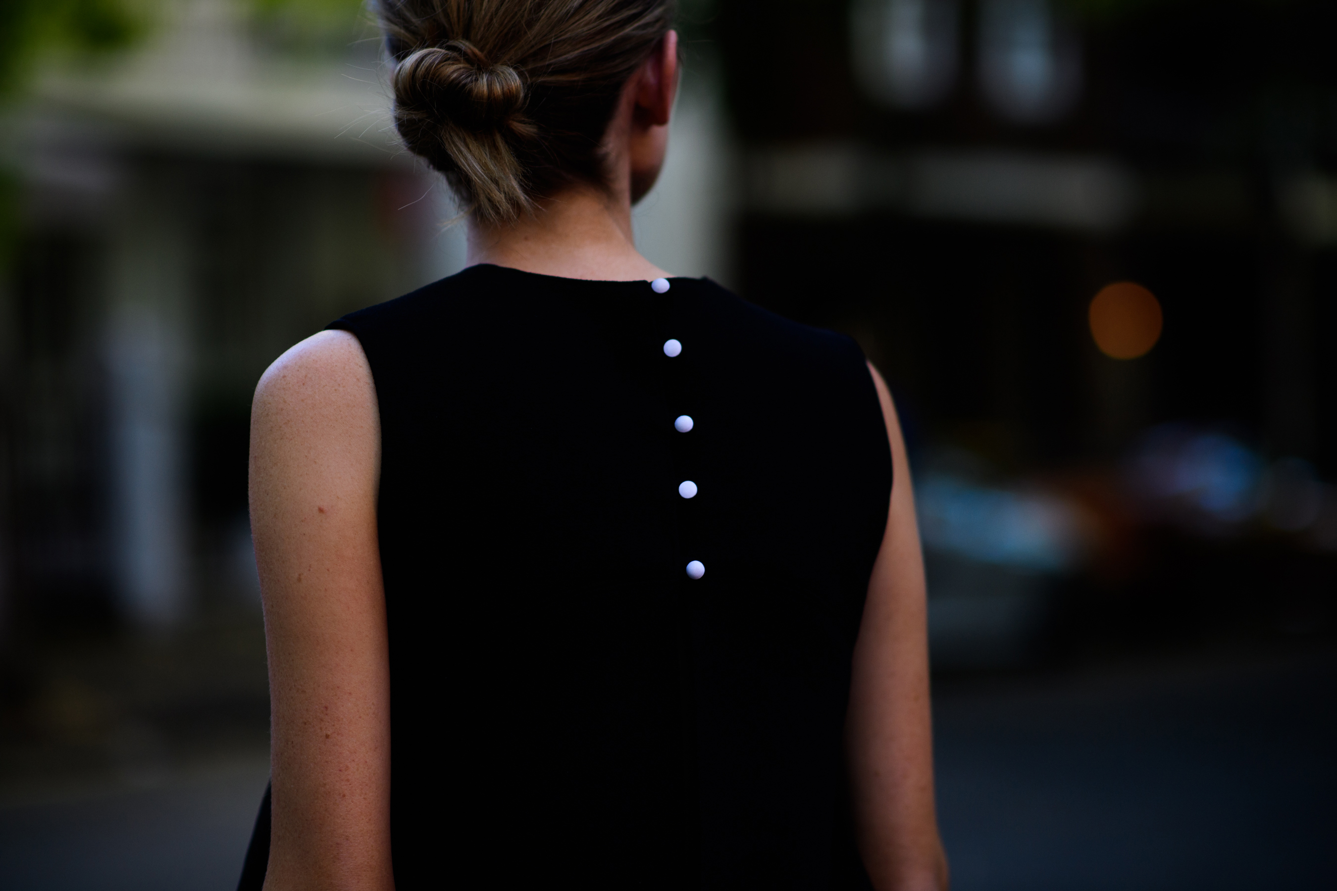 Woman wearing black top with pearls