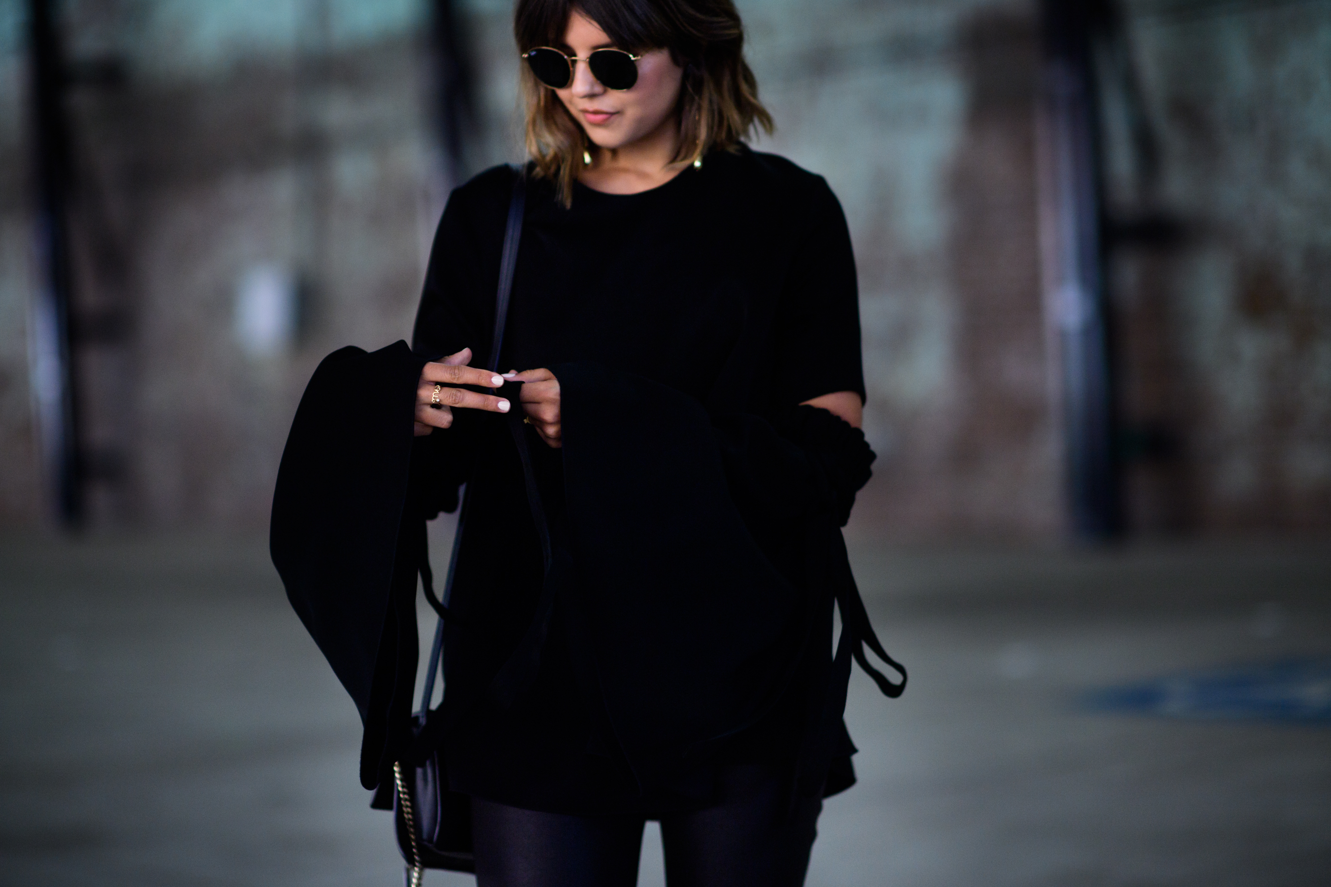 Woman wearing black outfit and glasses