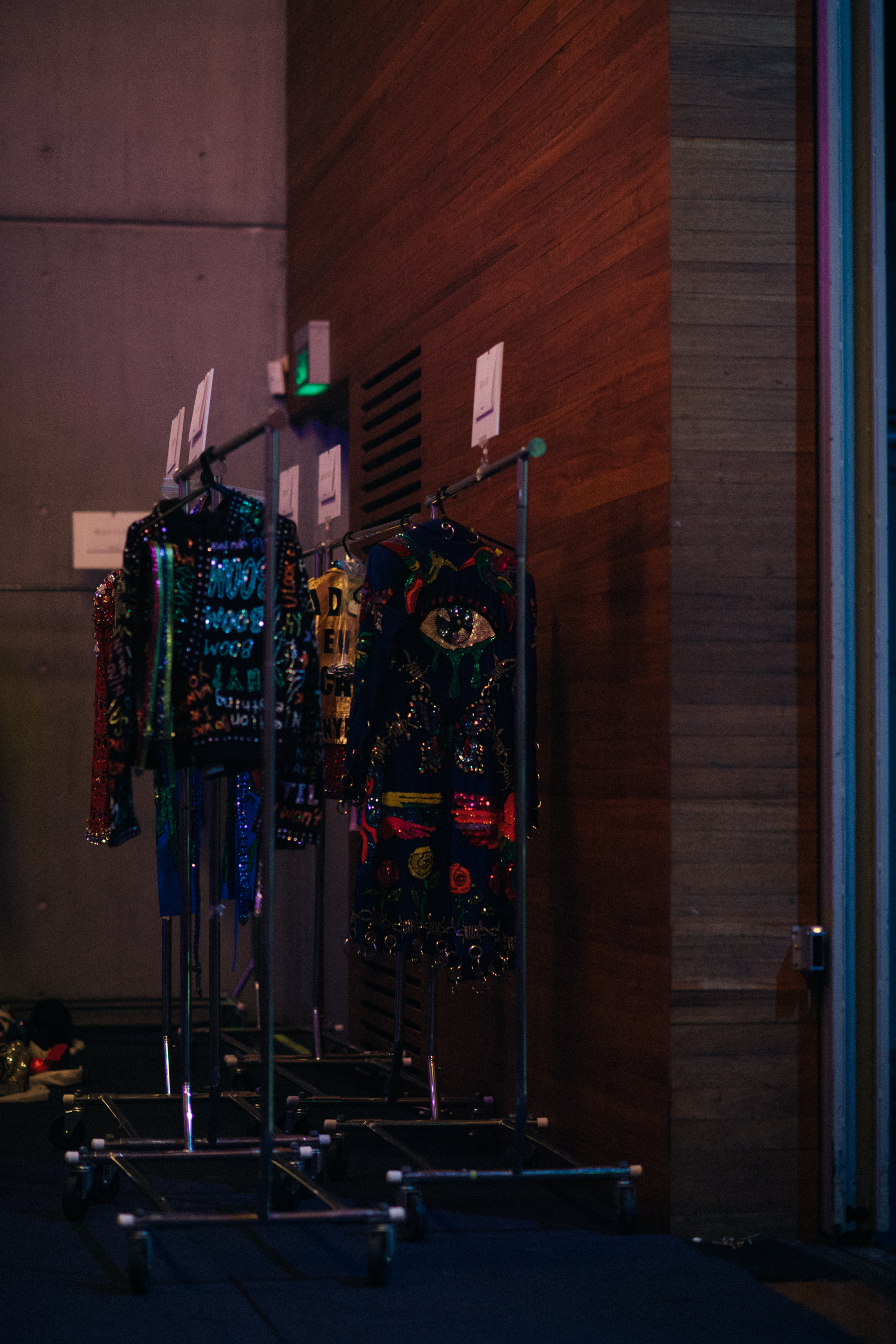 Bright glitter dresses on racks backstage