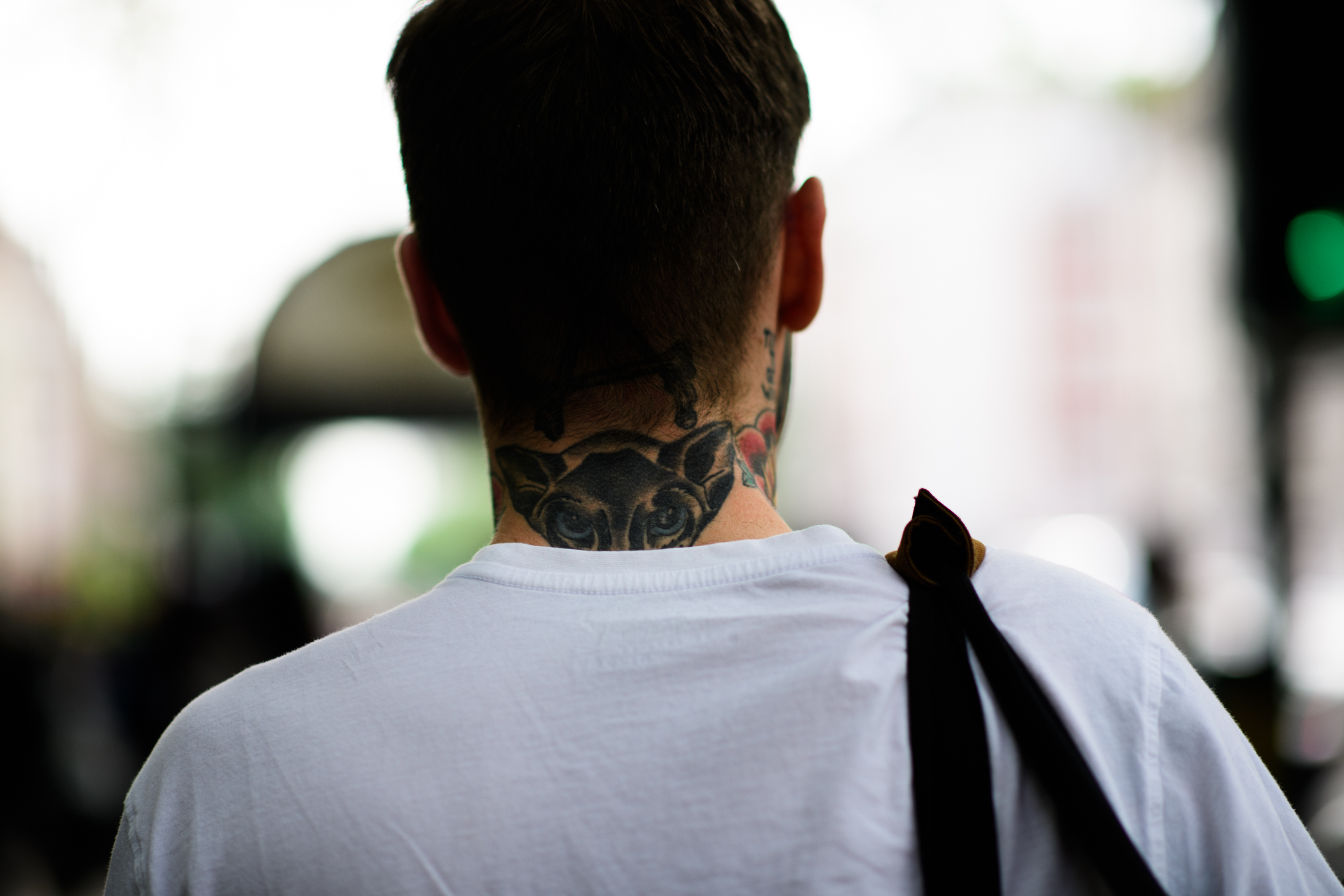 A tattoed young man in a white T-Shirt