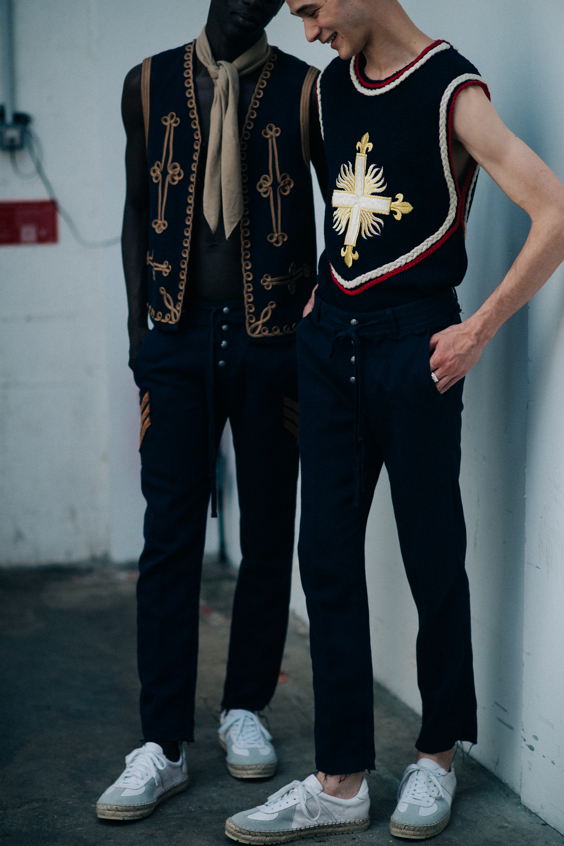 Two models wearing black vests