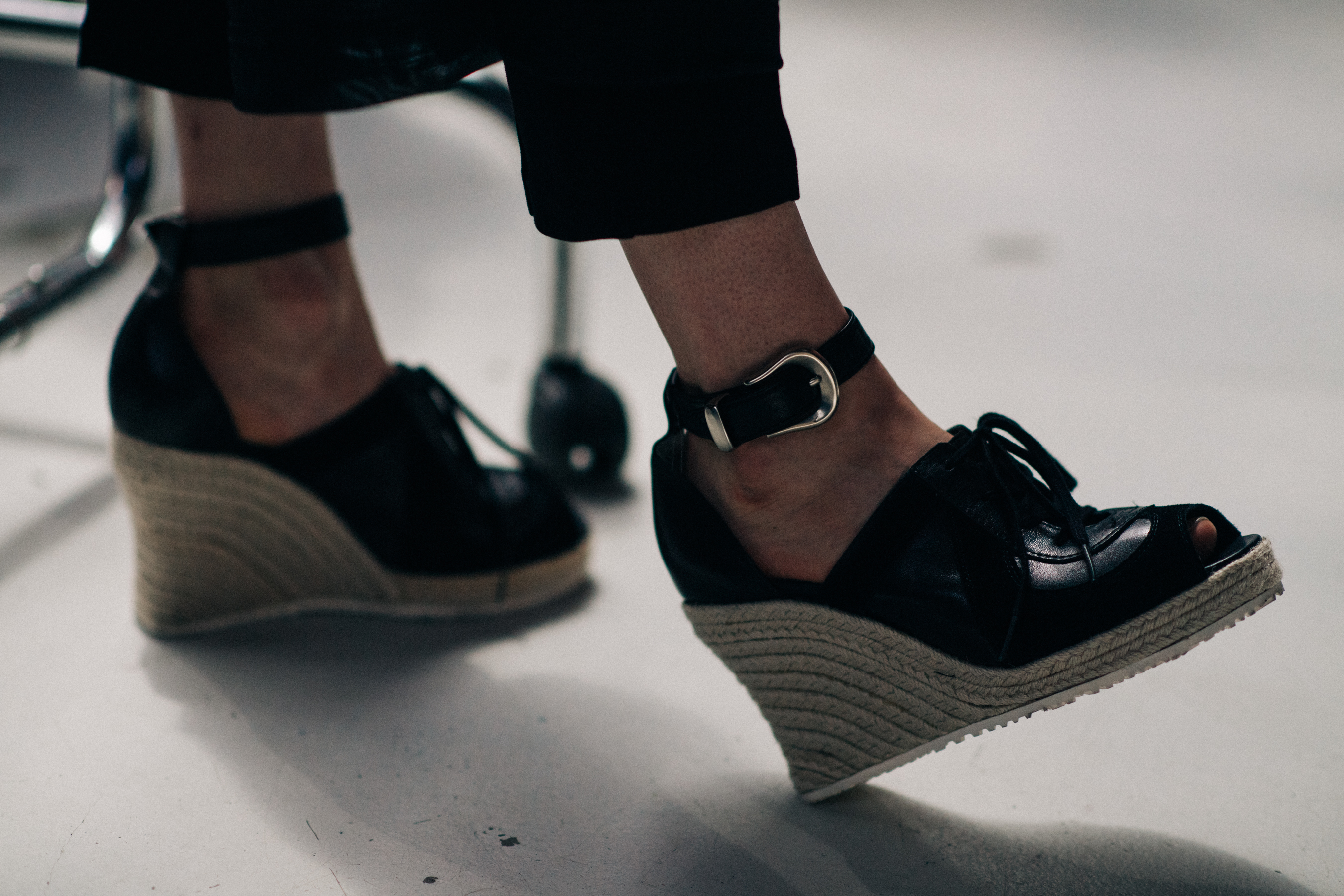 Female model wearing black wedges