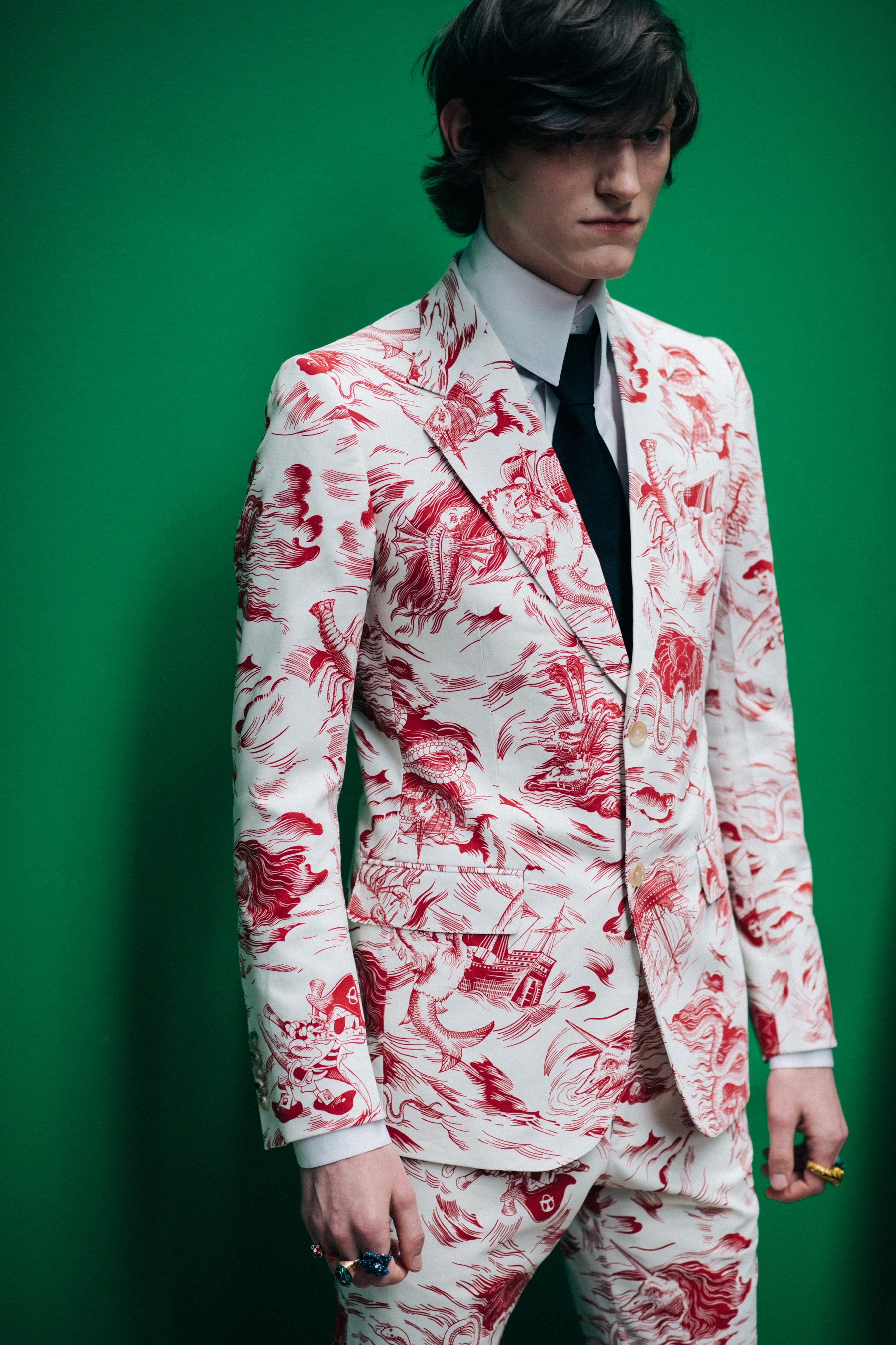A man in a white suit with red roses
