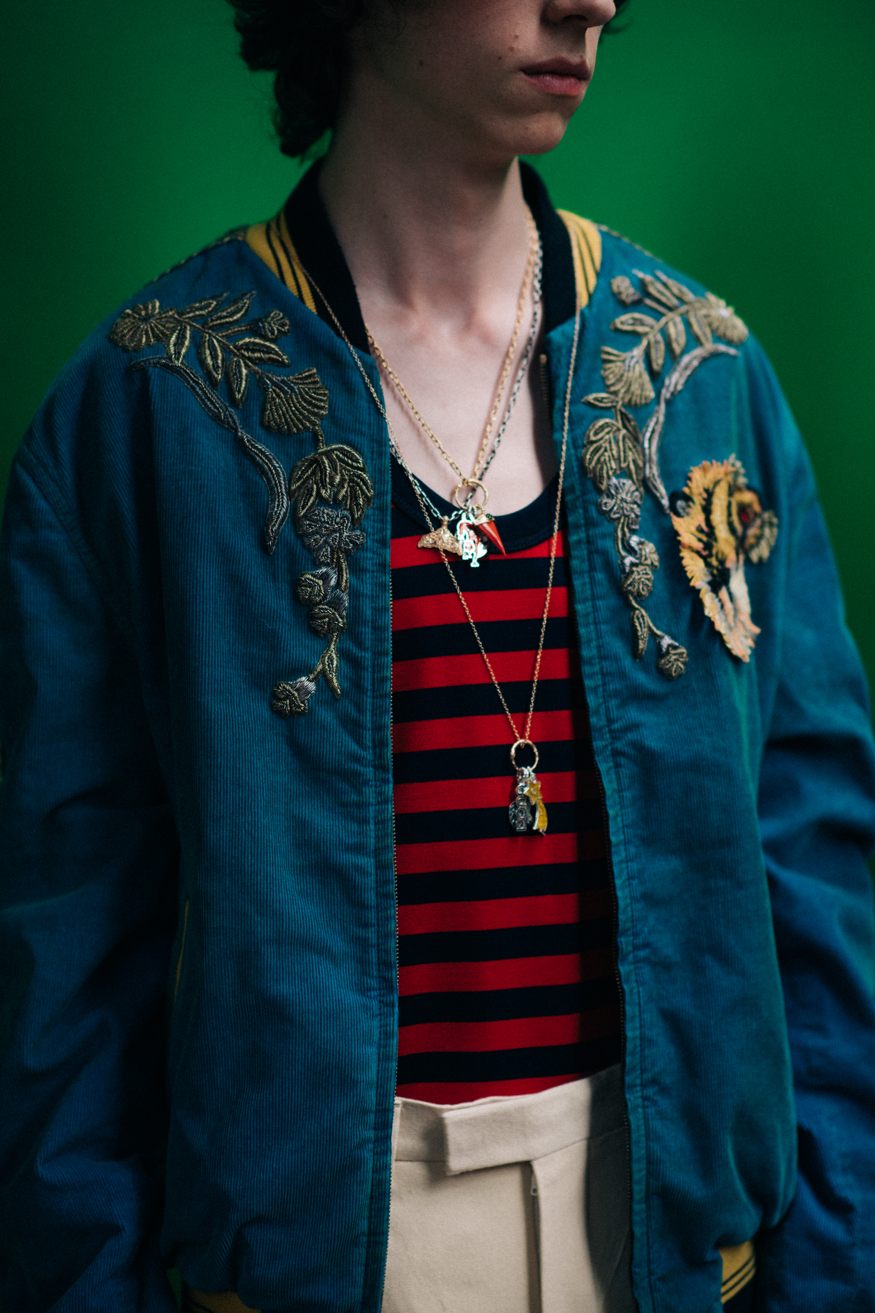 A man wearing a green bomber jacket