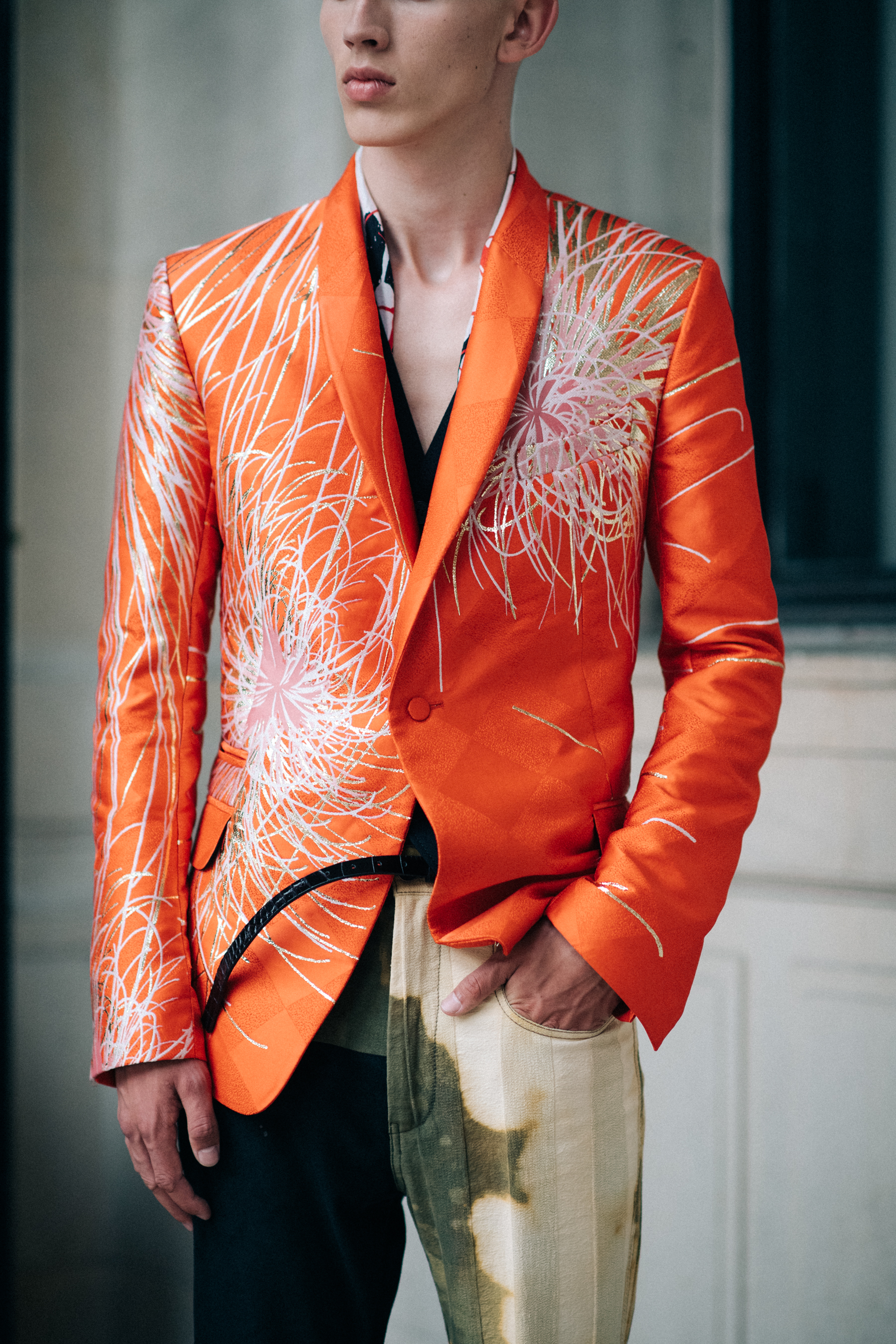 A male model wearing an orange jacket