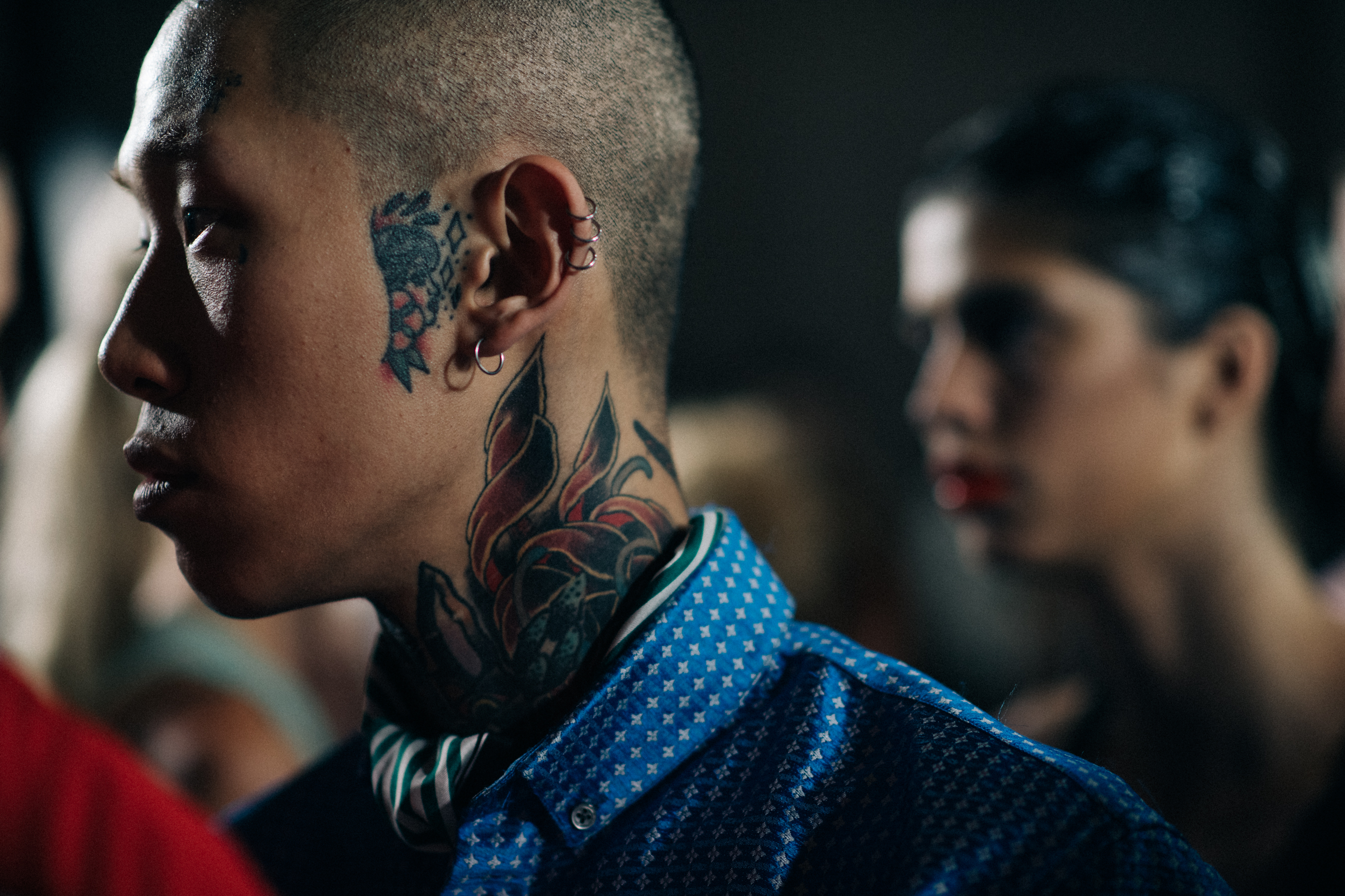 A tattooed man in a blue shirt