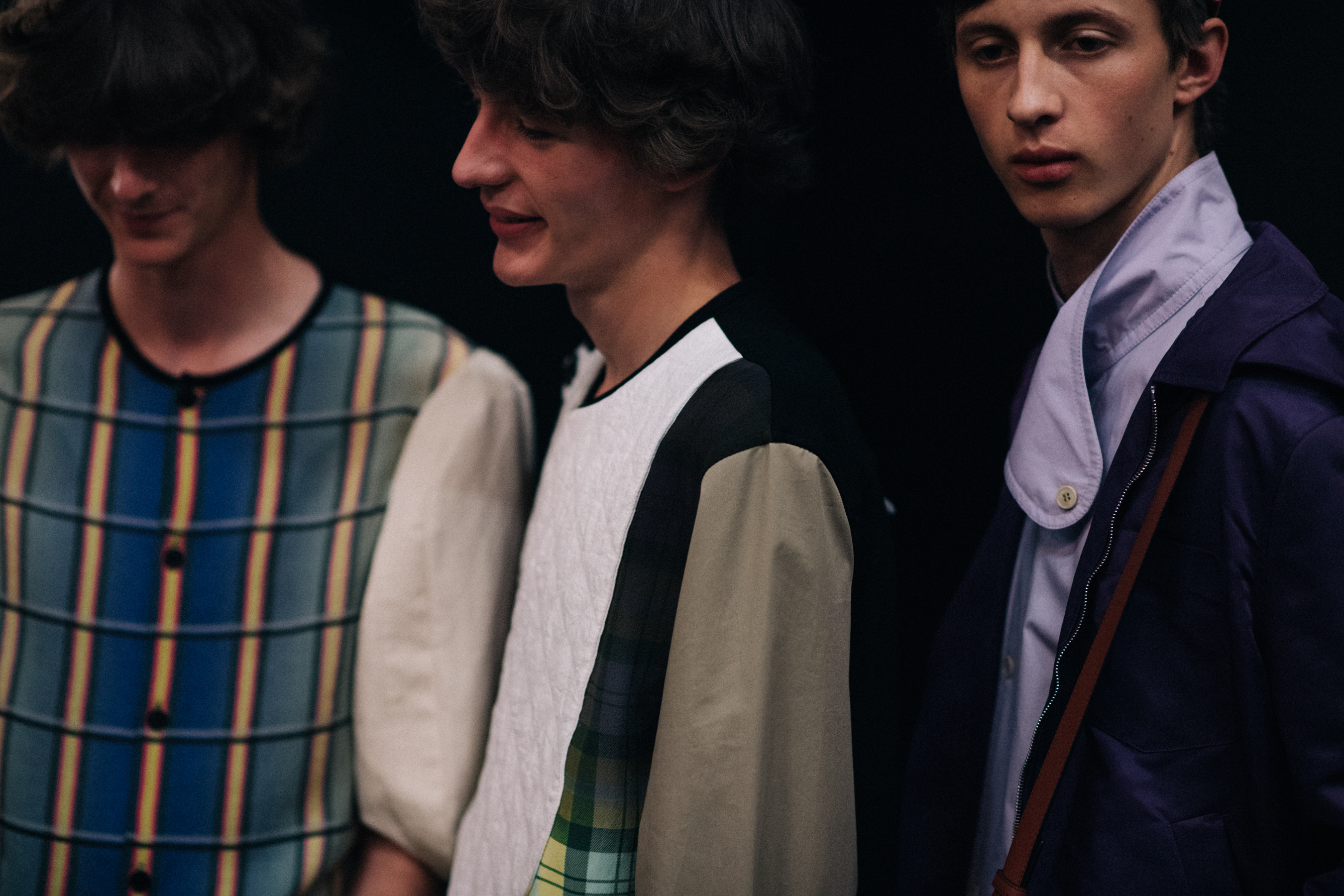 Three models posing together backstage