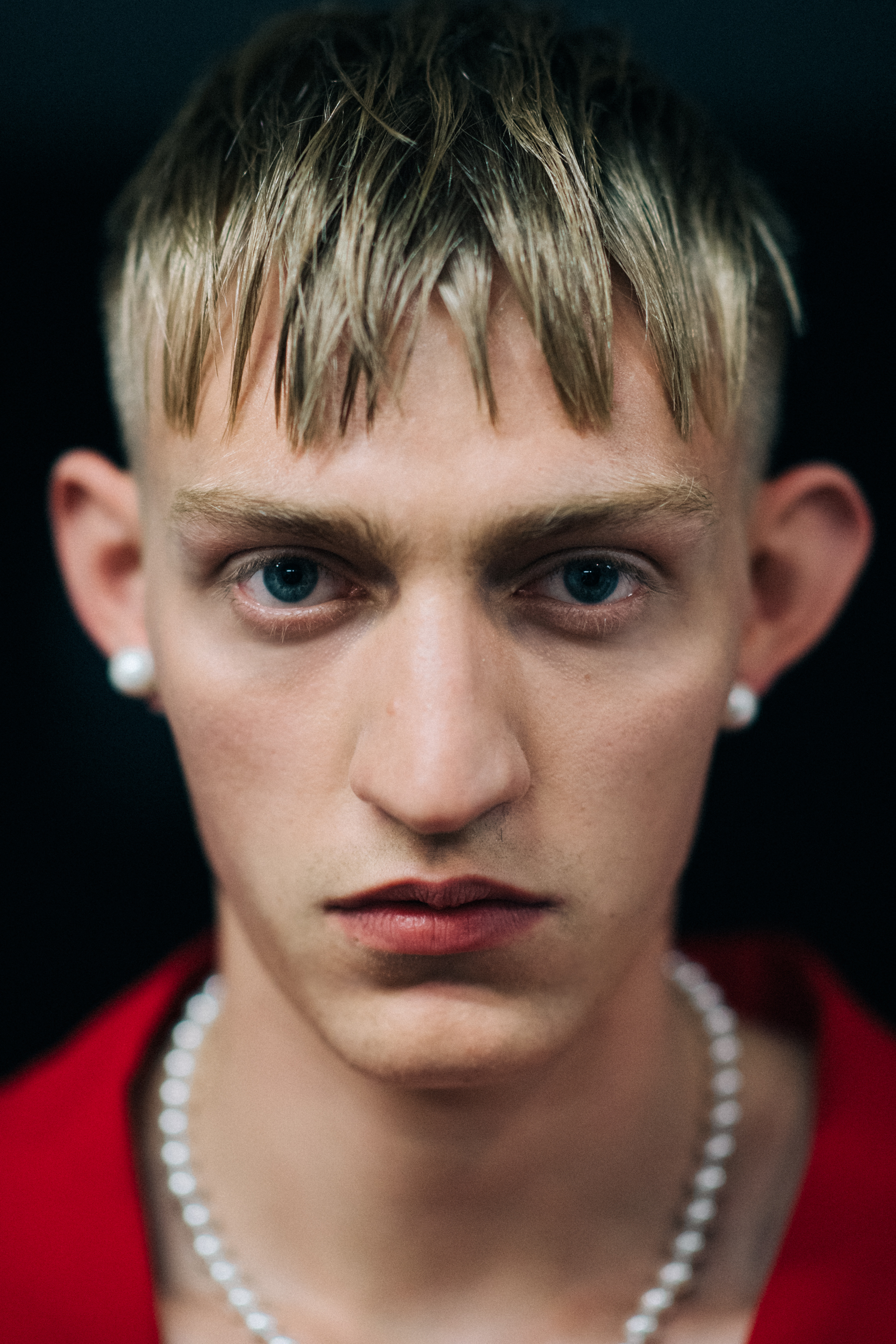 A male model with earrings and a necklace