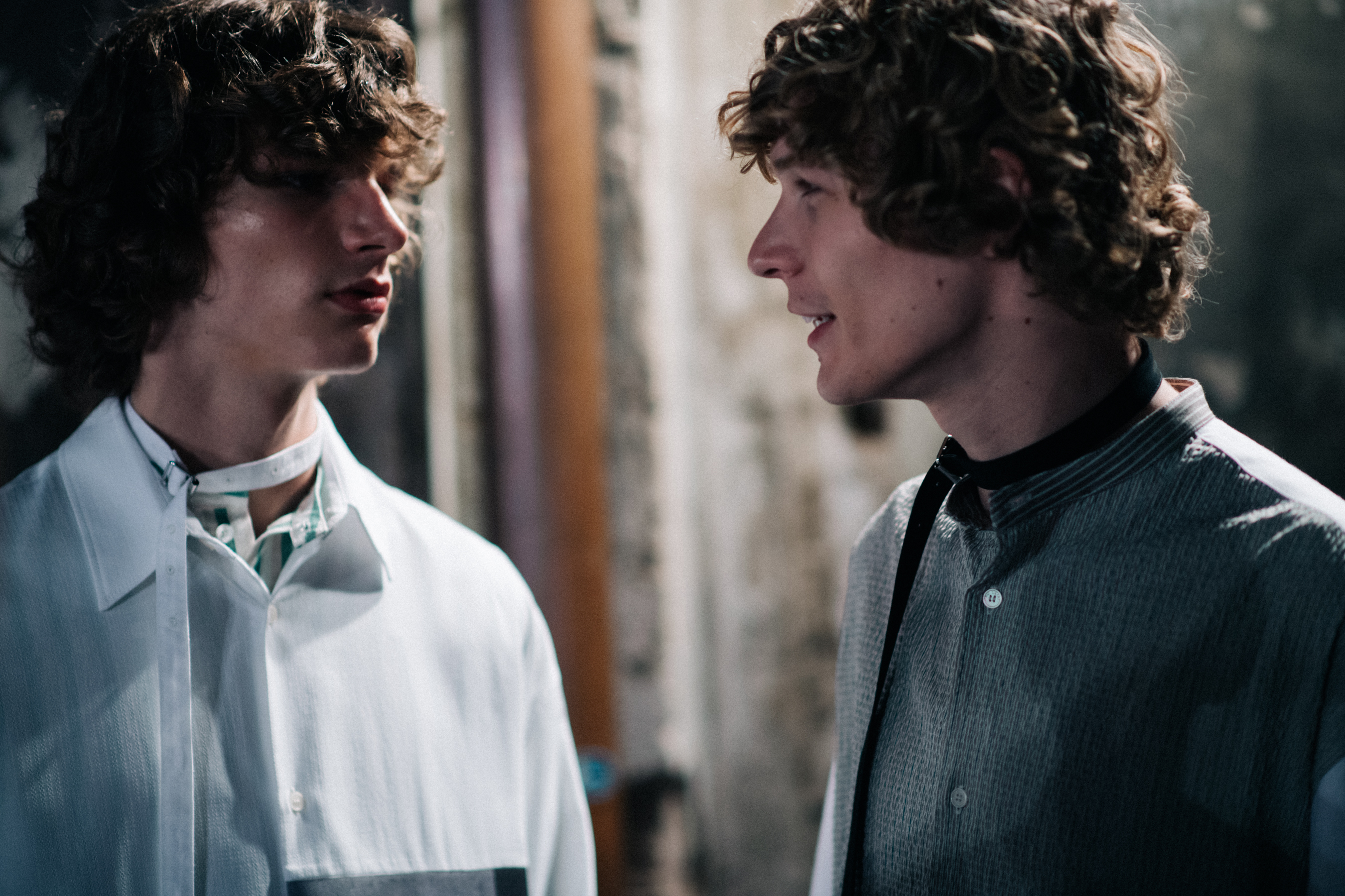 Two curly-haired models talking