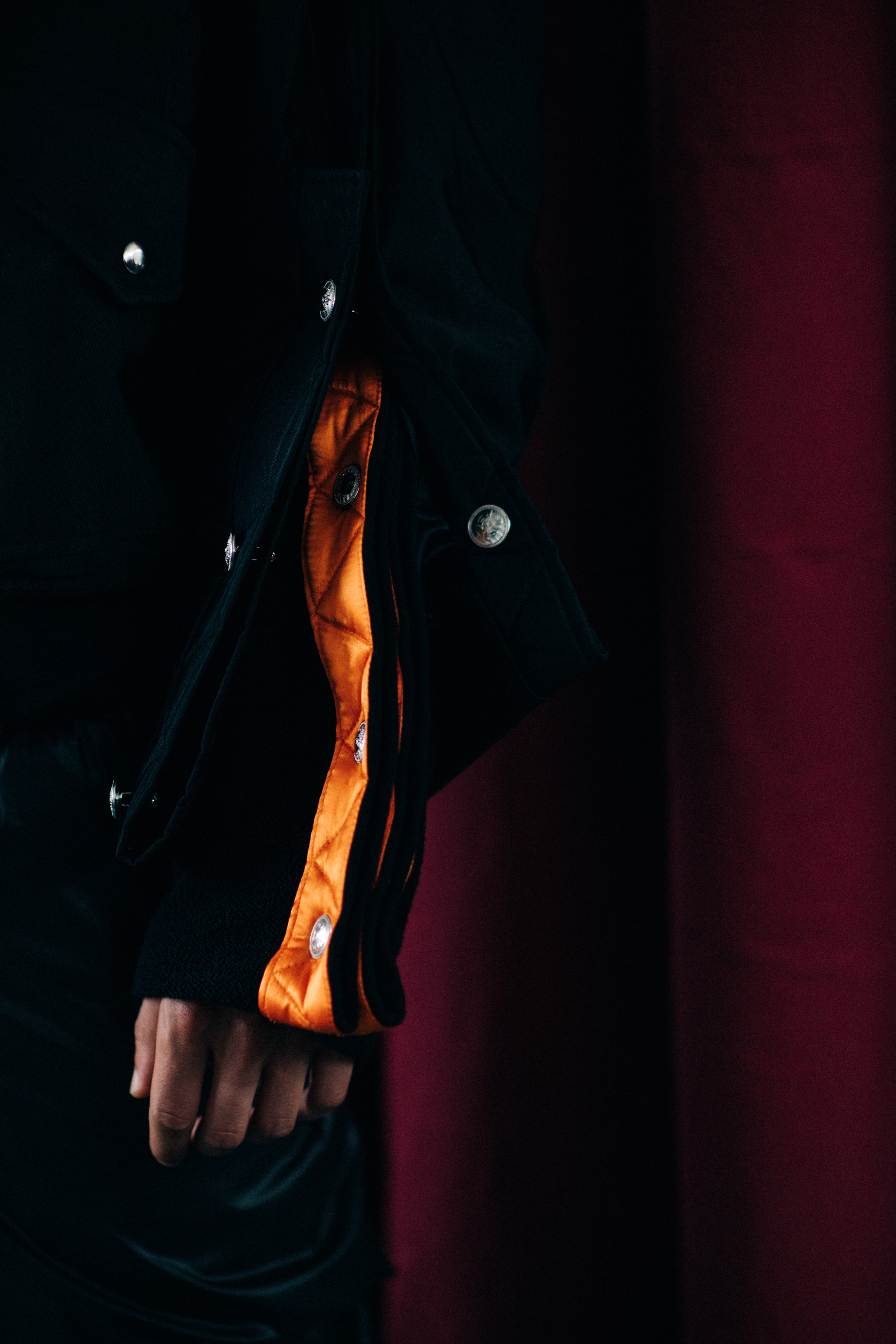 Details of a black jacket with orange stripes