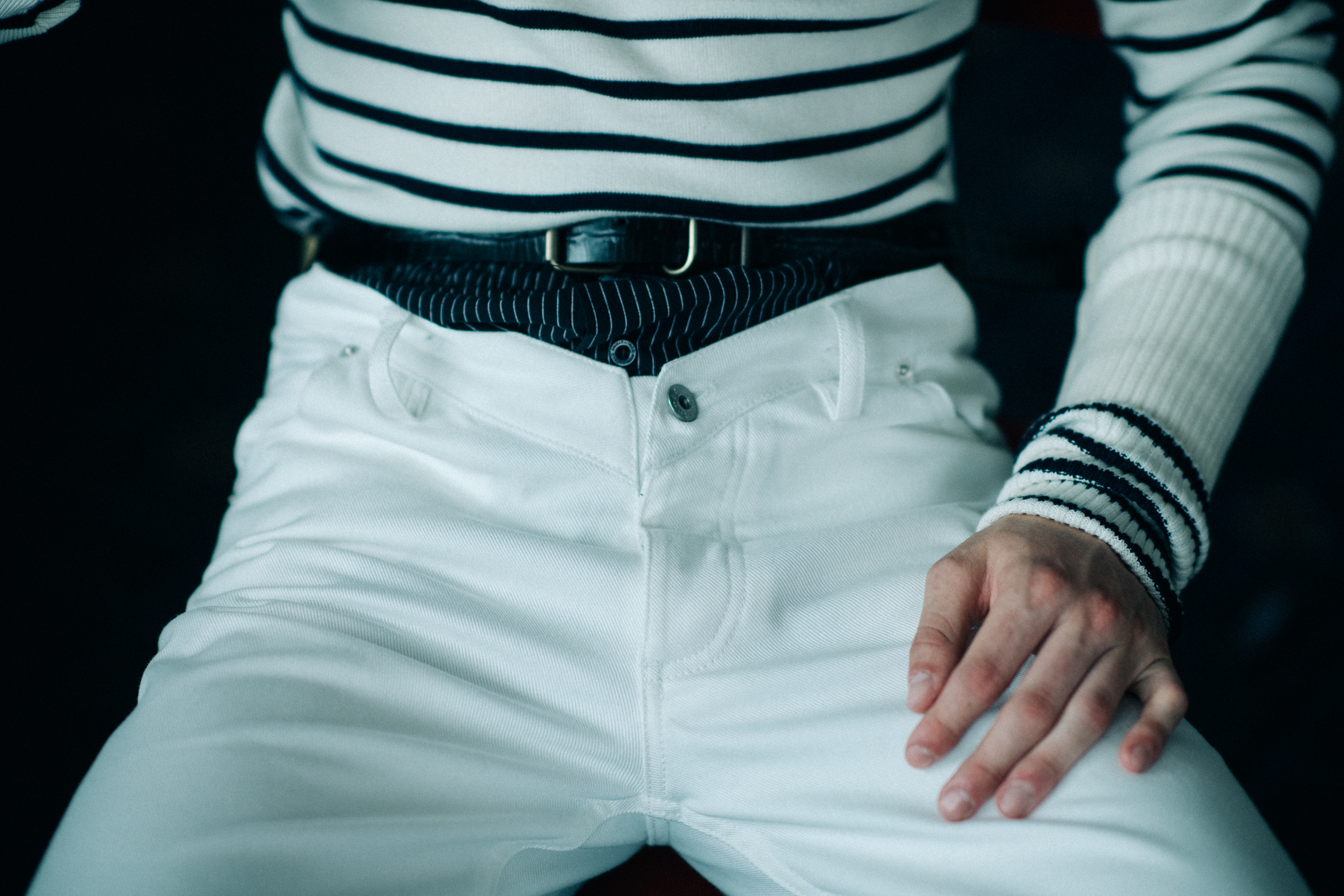 White trousers worn over dark jeans
