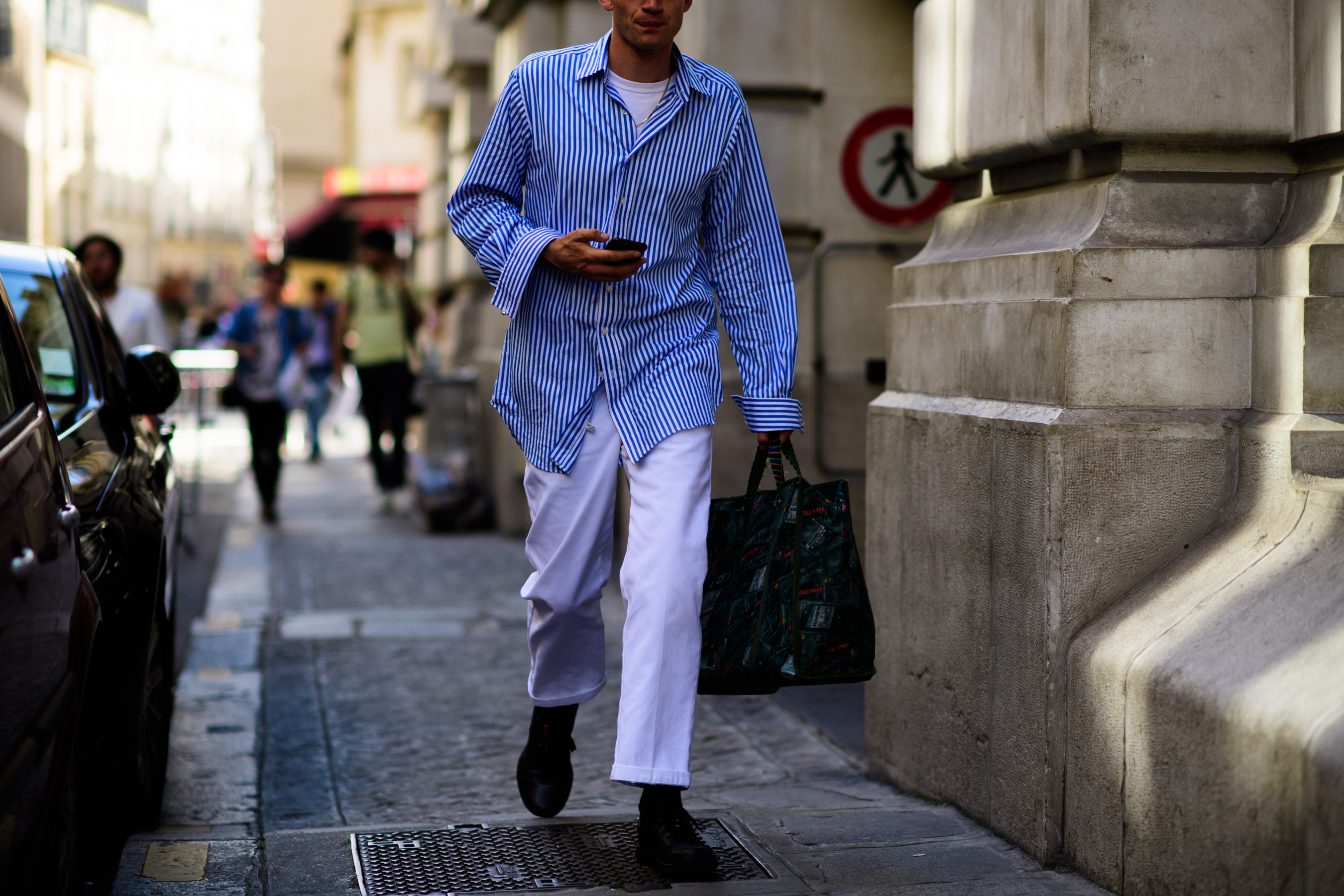 A man in whit trousers, blue shirt