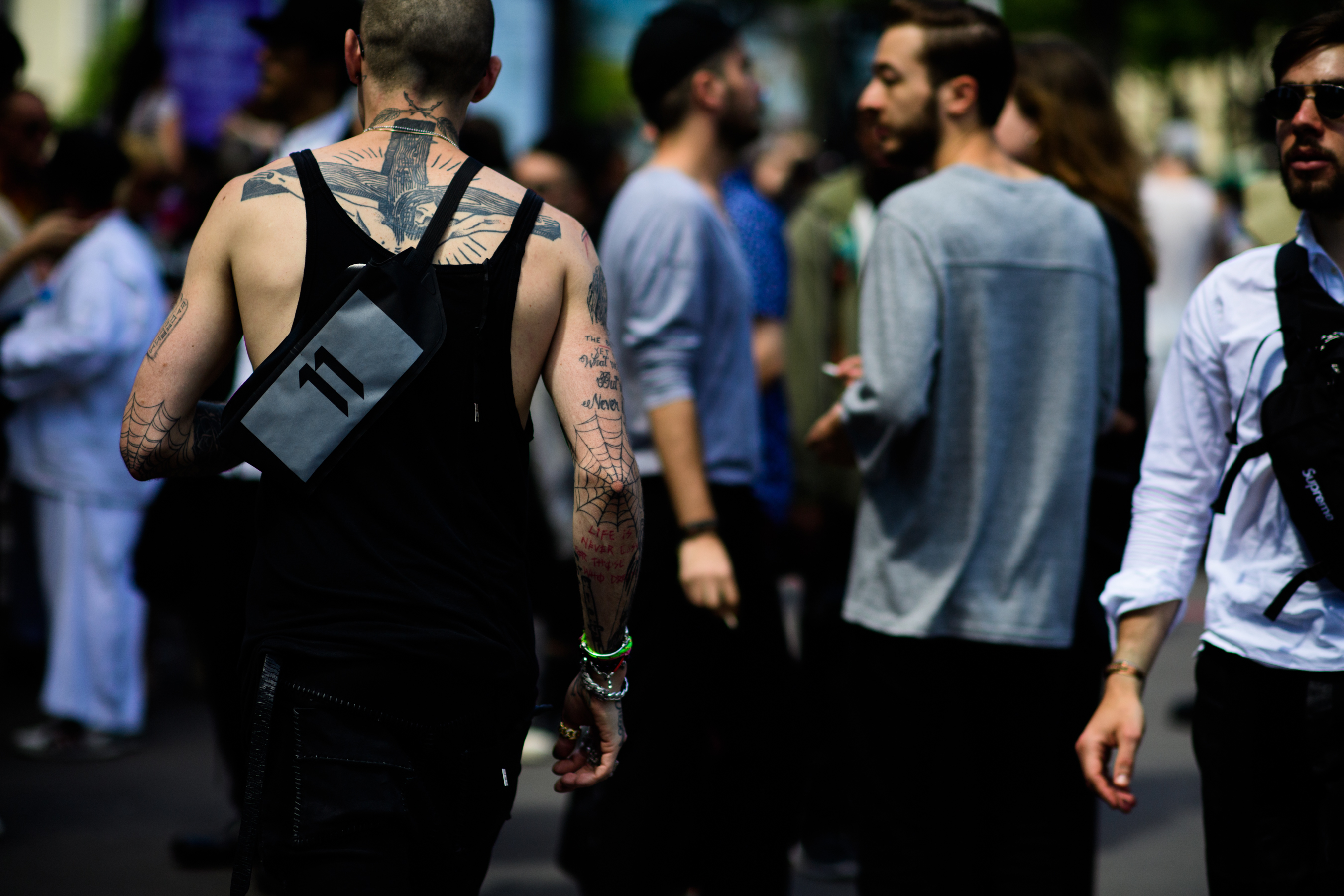 A tattooed man in a black vest